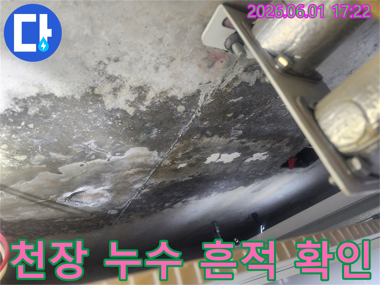 누수로 인해 얼룩지고 곰팡이가 생긴 콘크리트 천장 표면-배관 지지대 주변의 물기 흔적