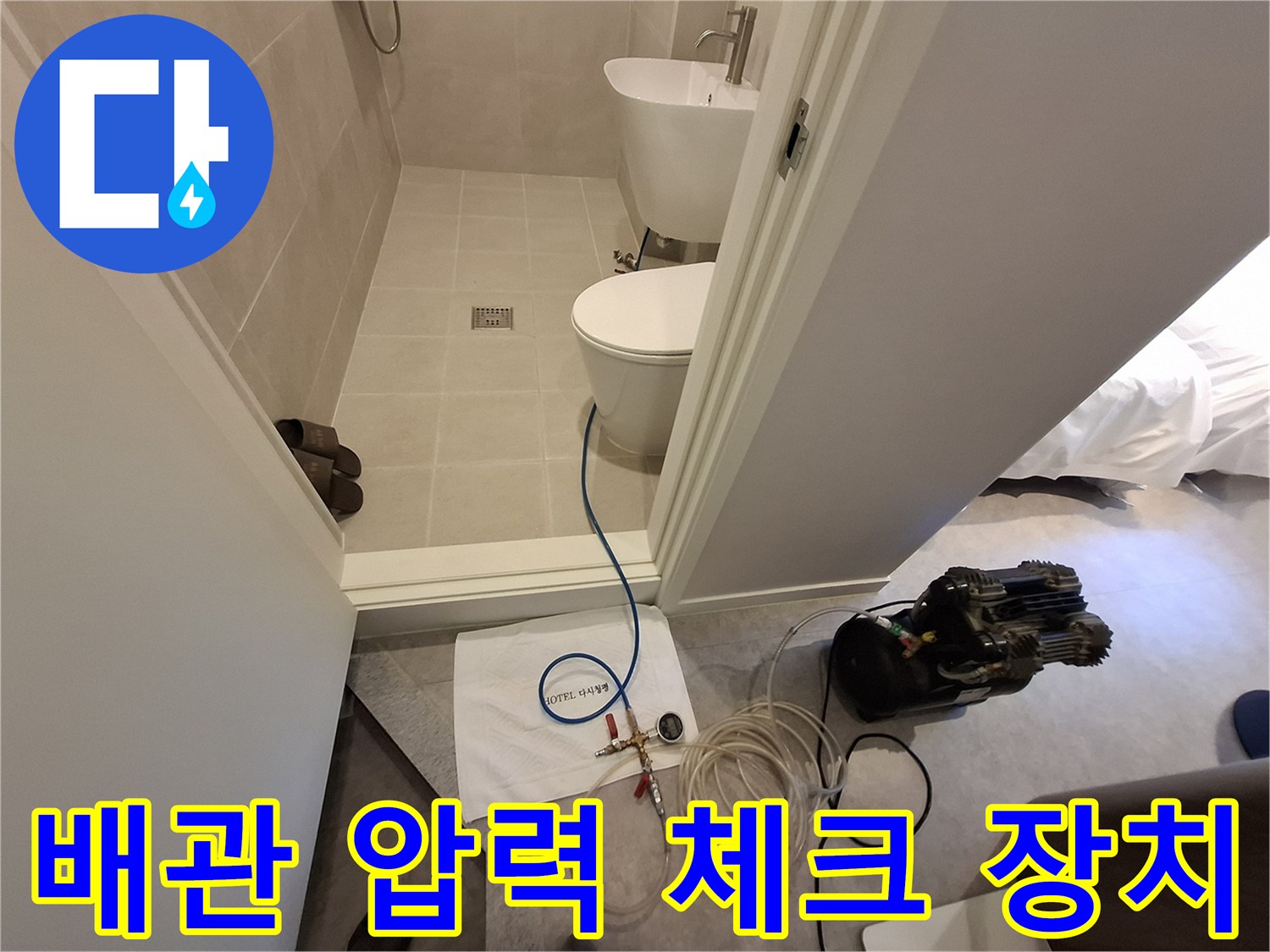 욕실 입구에 설치된 배관 내 압력을 측정하기 위한 가압 펌프와 호스