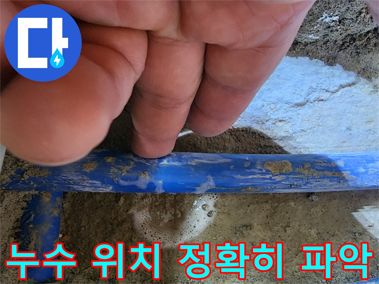 엔지니어의 손가락이-파란색 배관의-누수 지점을 가리키며-거품으로 누수를-확실히 보여주는 사진