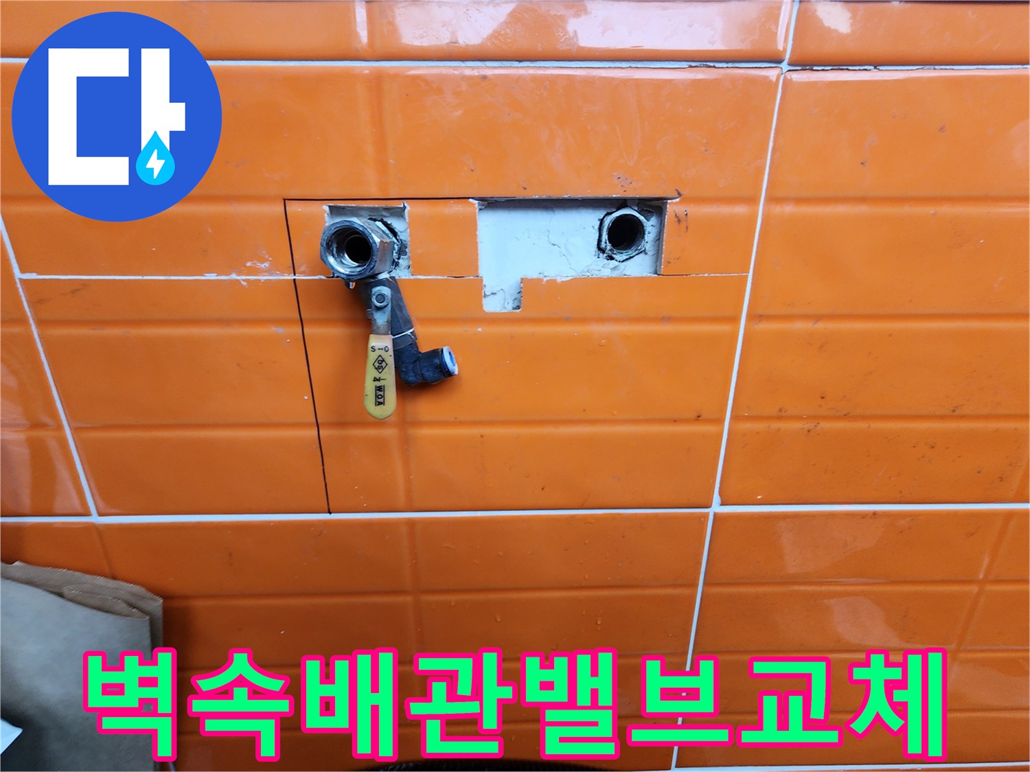 오렌지색-타일이-부분적으로-제거된-곳에-새로운-수도-밸브가-설치된-배관-수리-과정을-담은-사진입니다.