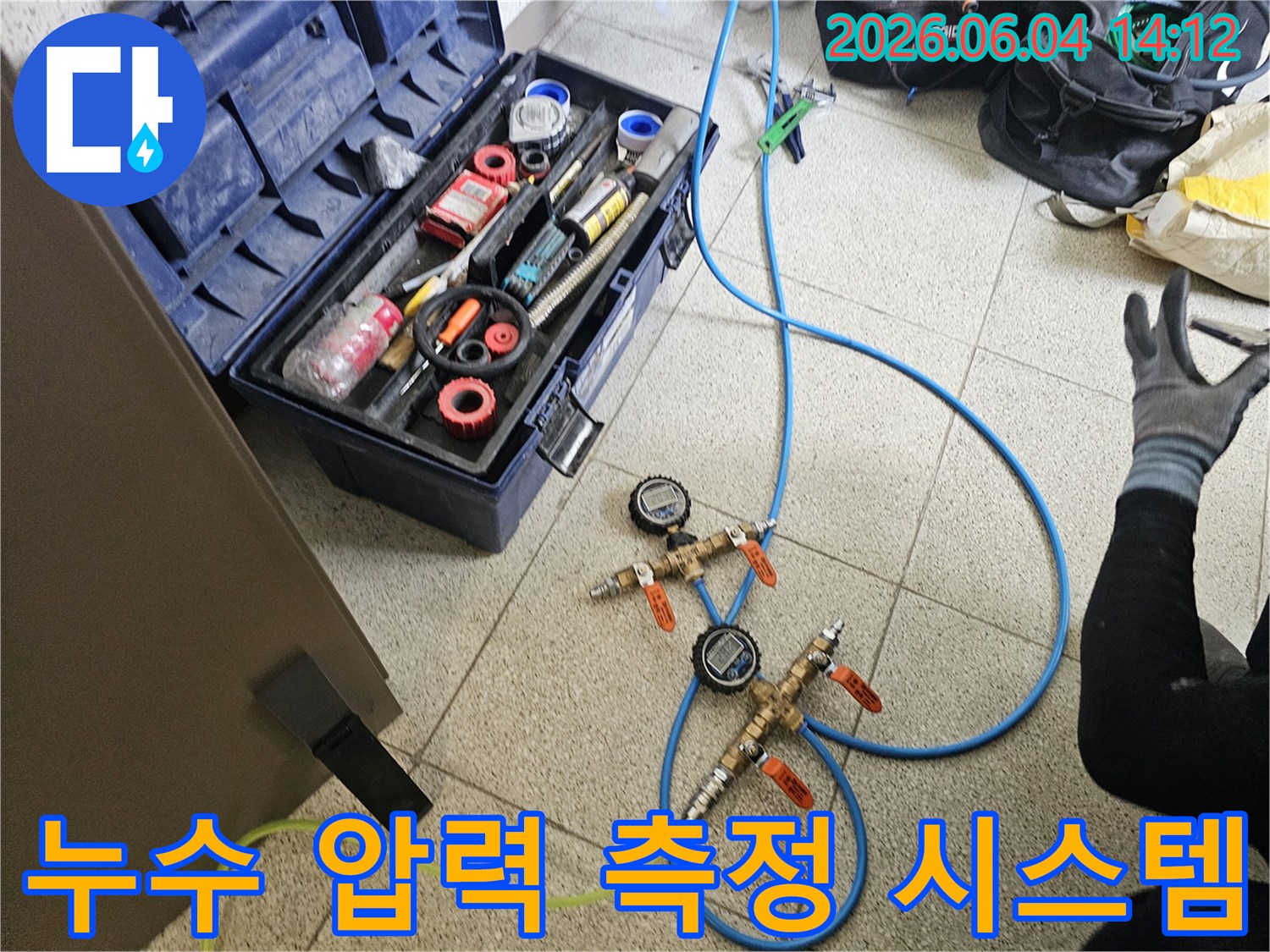 누수-탐지를 위해-설치된-정밀 압력-측정 장비와-다양한-전문-공구들이-함께-보이는-현장입니다.