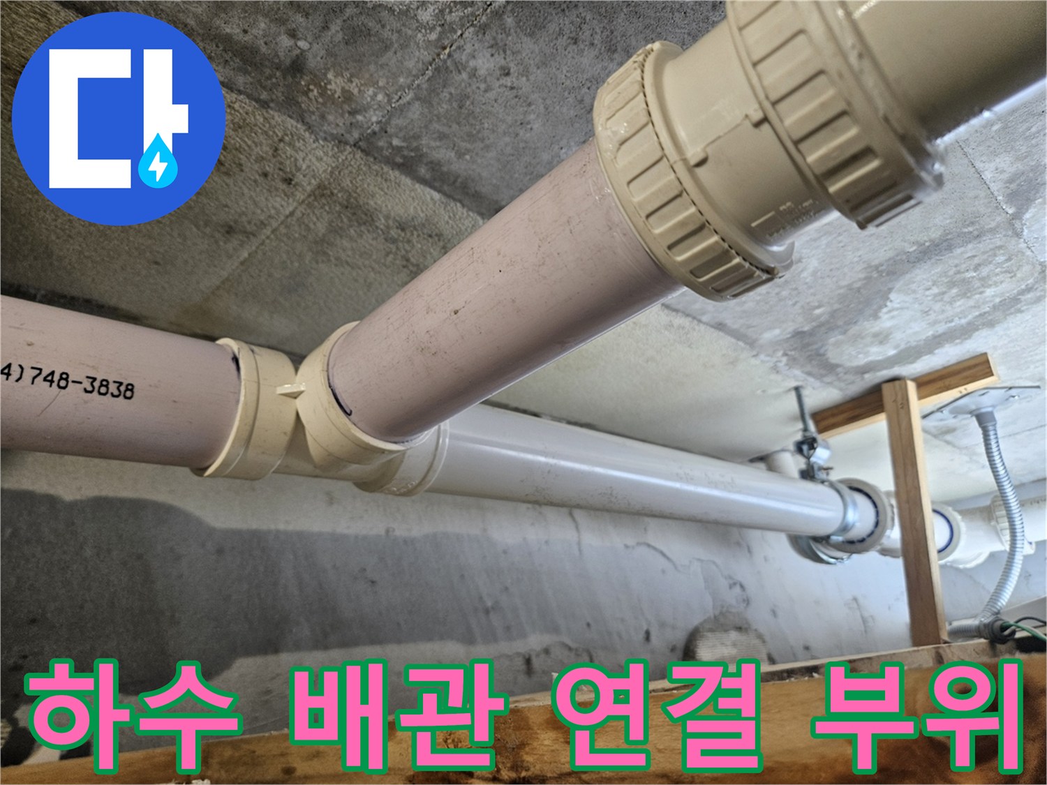천장 구조물에 고정된 흰색 하수관 연결부 상세 사진
