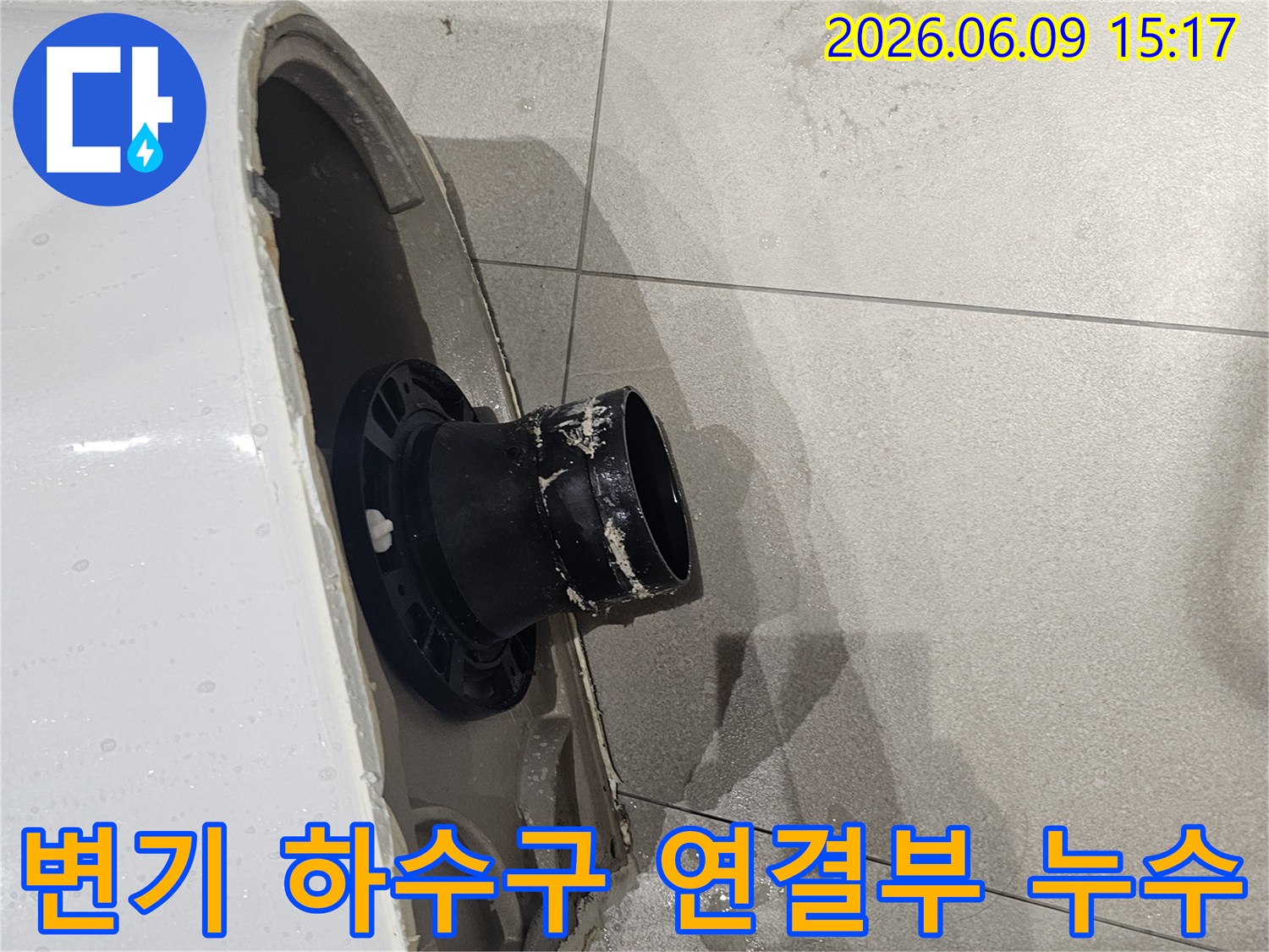 변기가 제거된-욕실 바닥의-오수 배관 주변에-물이 고여있는-모습을 보여주는-누수 현장-사진입니다