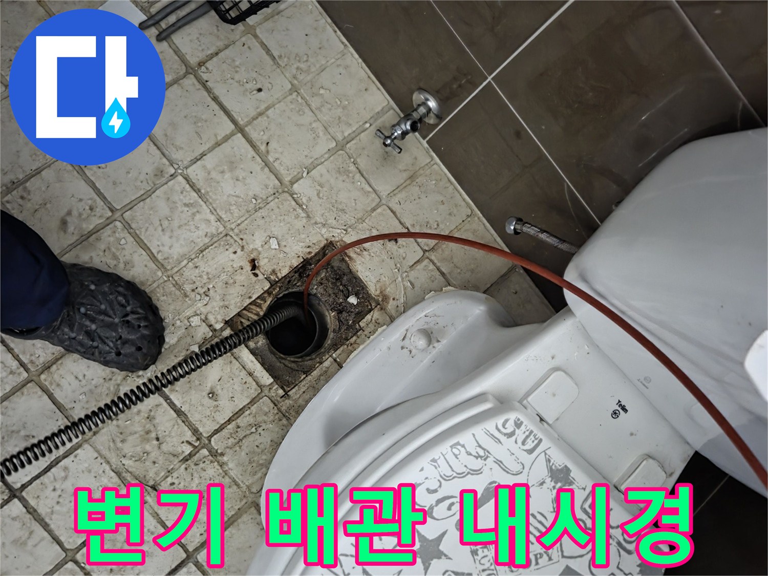 변기 옆 바닥 배수구에-내시경과-스프링 장비가-투입되어-배관 역류 원인을-찾고-해결하는-작업 현장