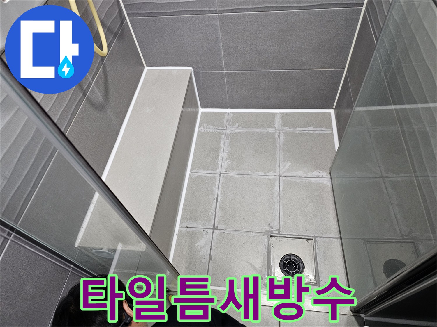 강동구 지역의 주택 욕실에서-타일 틈새로 인한 누수를 막기 위해-전문가가 방수 실링 작업을 하는 현장입니다.