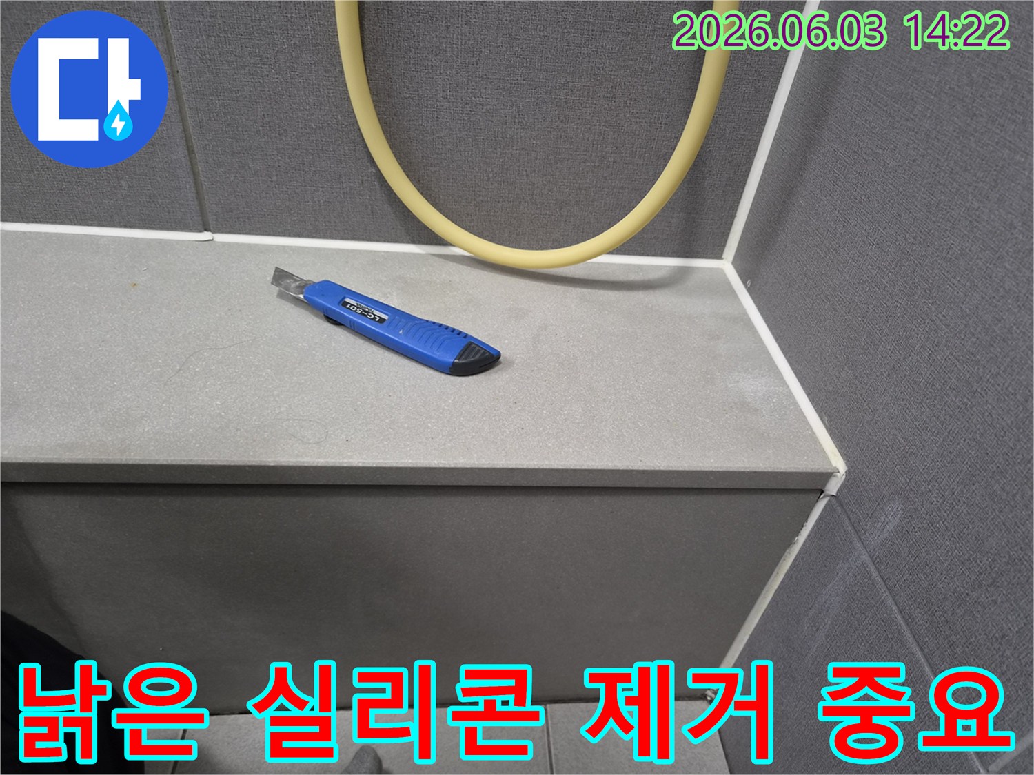 누수 보수 작업을 위해-커터칼이 놓여있는-욕실 타일 모서리 부분