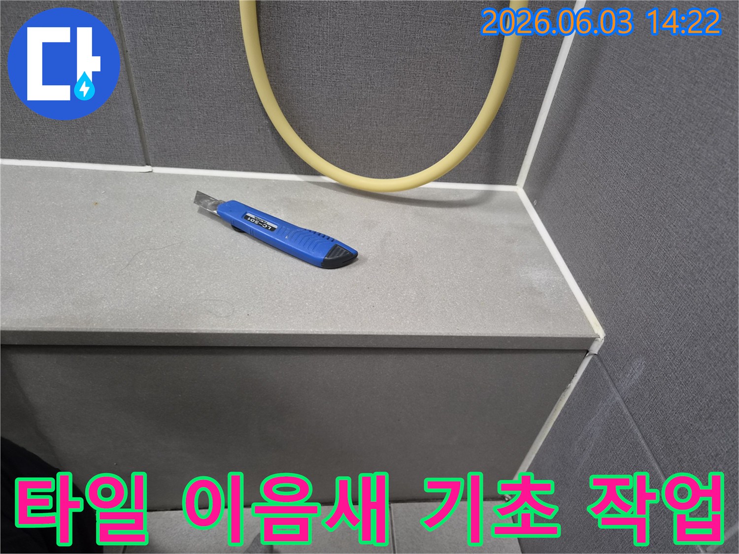누수 보수 작업을 위해-커터칼이 놓인-타일 모서리 부분의 클로즈업