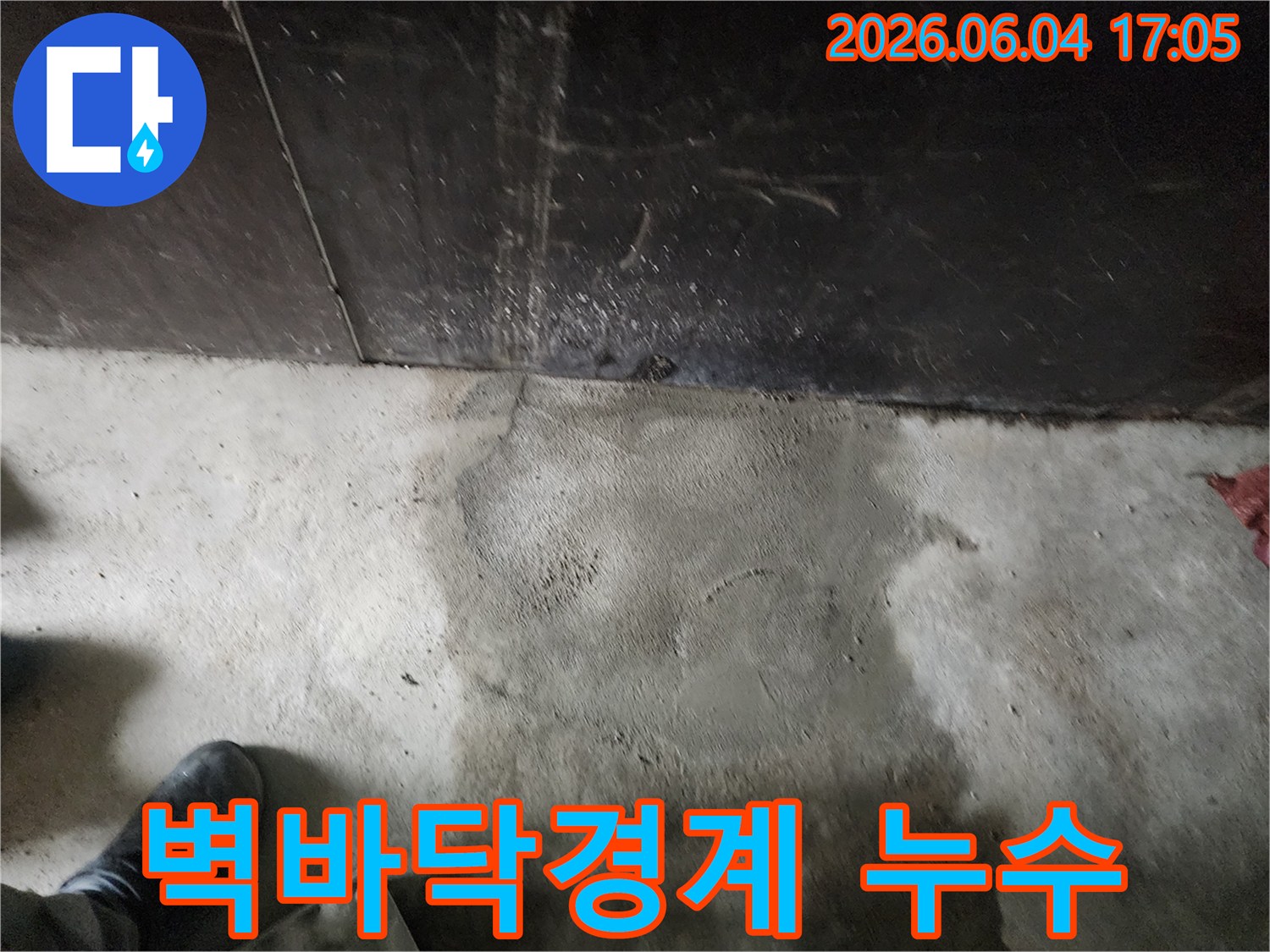 누수 엔지니어가-구로구 구로동 현장에서-벽과 바닥의 경계면에서-발견된 누수 흔적을-세심하게 관찰하는 장면