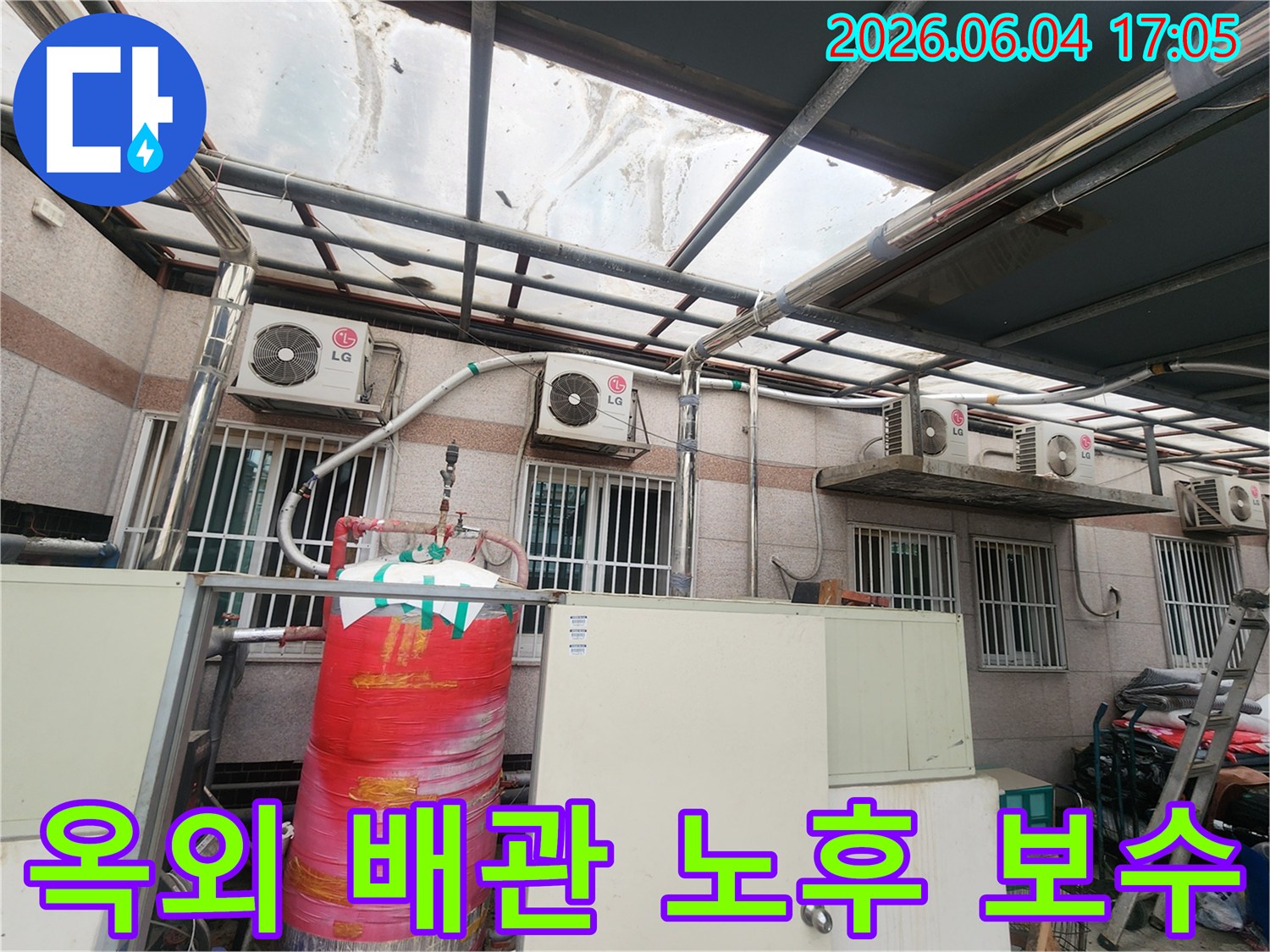 이 이미지는 주택 외부에 설치된-오래된 배관들과-다양한 설비들이 복합적으로 배치된 모습을 보여줍니다