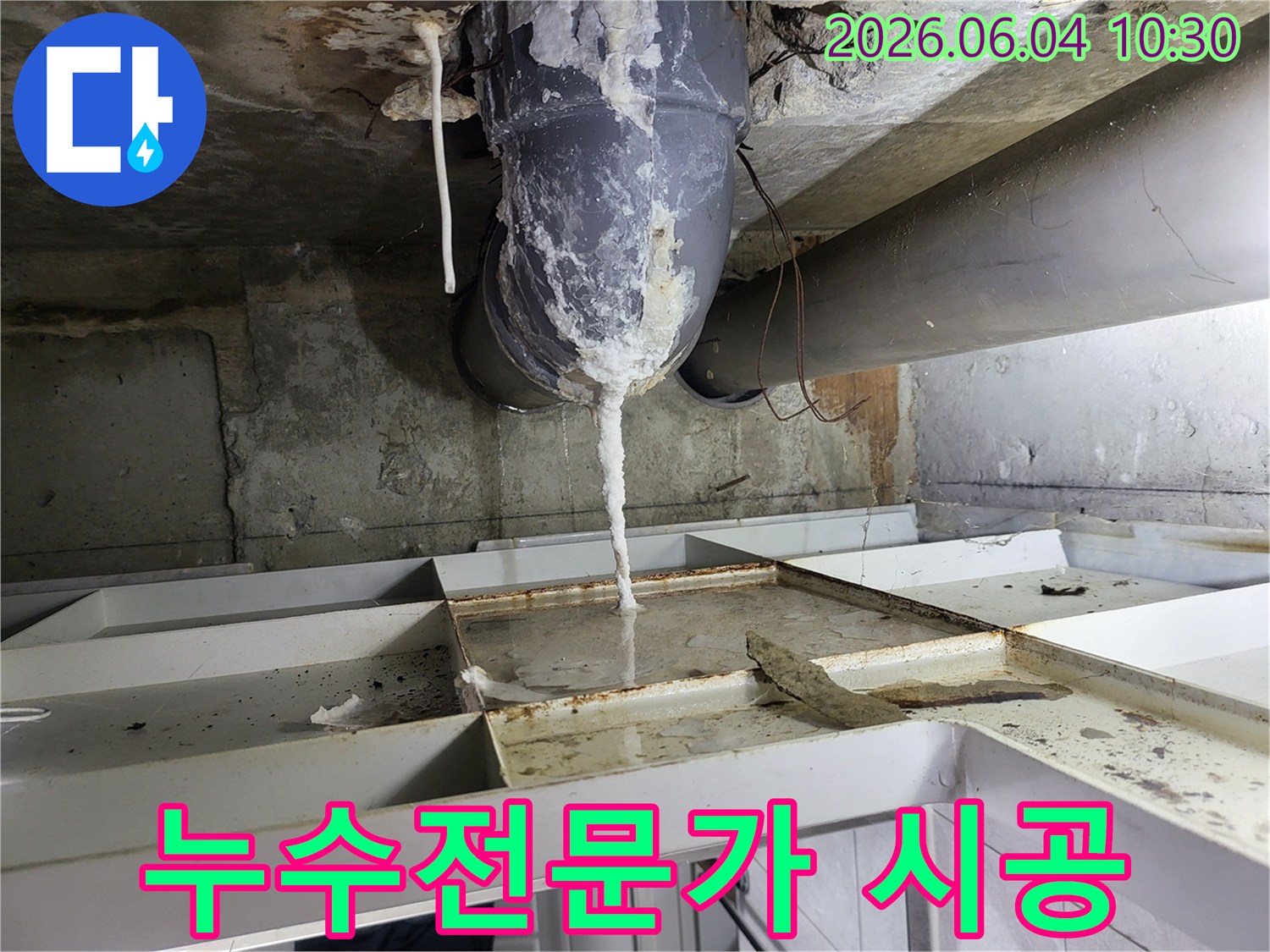 천장 배관에서 물이 새어 나와-석회질이 고드름처럼 맺히고-아래 바닥에 물이 고인 누수 현장