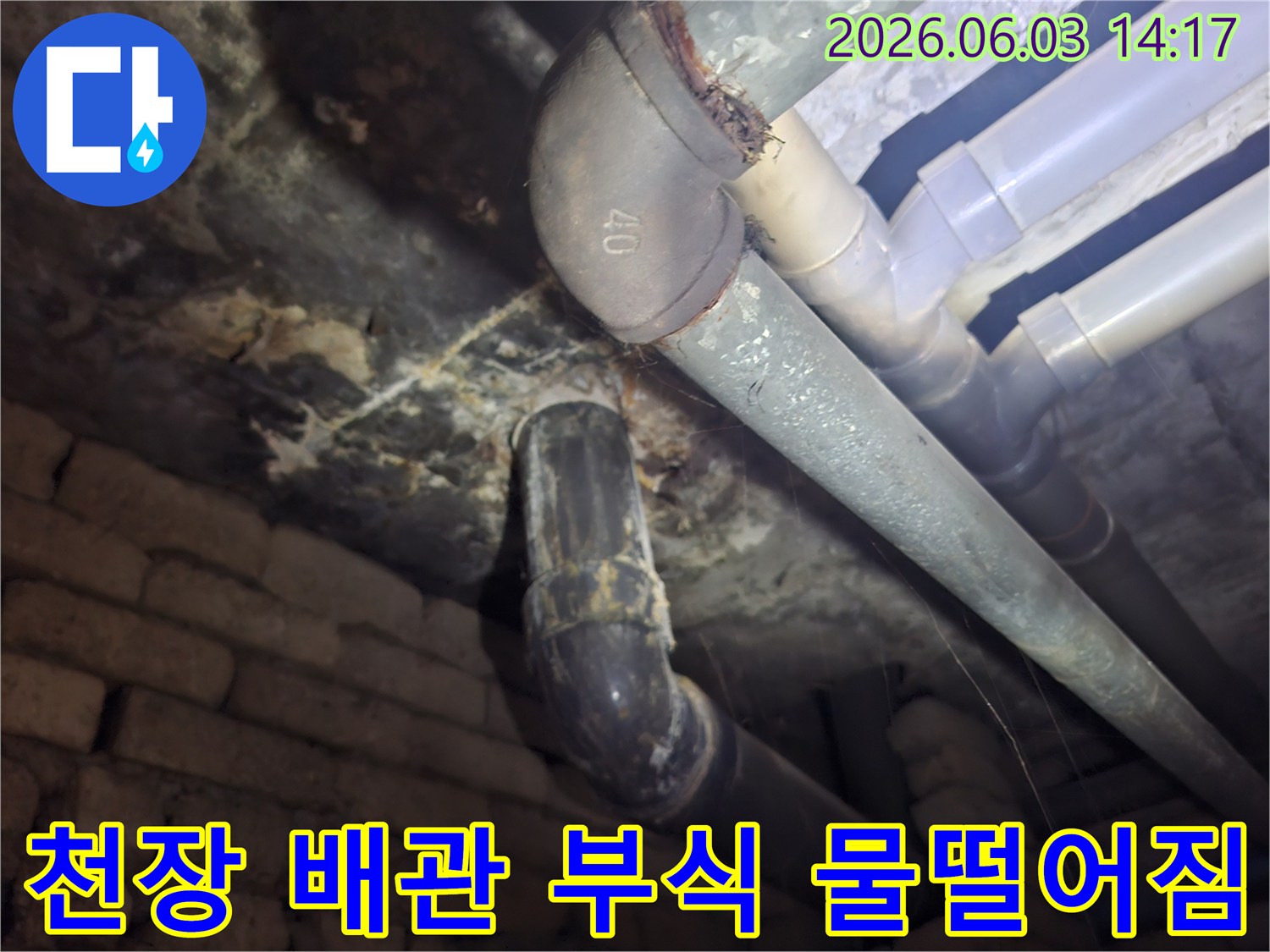 상가 천장 배관의 심각한 부식과-그로 인해 발생한 물떨어짐 현상을-면밀히 관찰하는 전문가의 시선