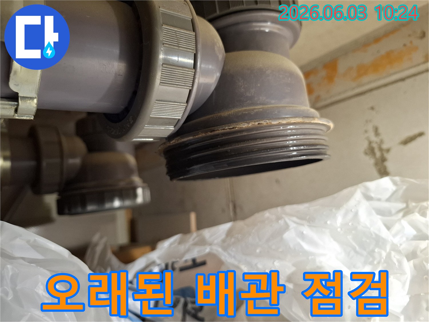 오래된 아파트 배관의-연결부에서 누수 흔적을 발견하고-정밀하게 점검하는 모습입니다.