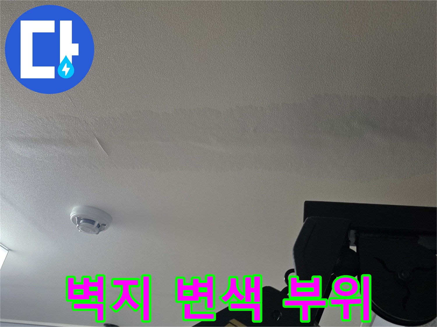 넓은 면적에 걸쳐 나타난 천장 벽지의 누수 흔적과 얼룩