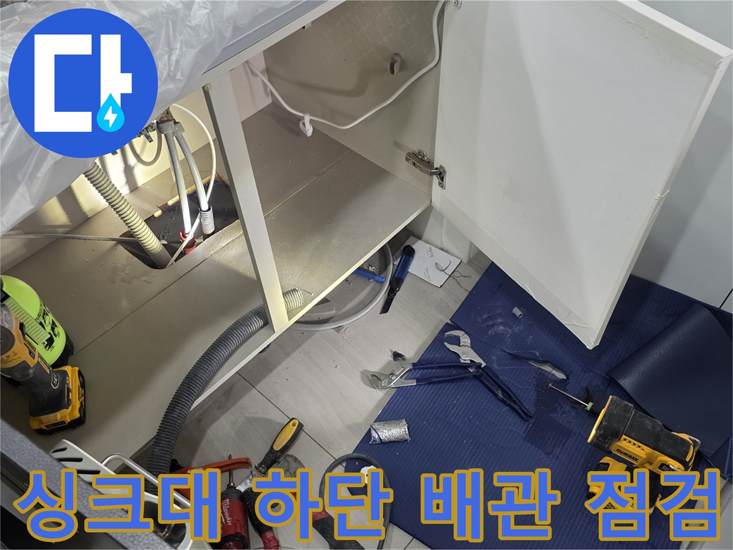 일산서구 주방 싱크대 하부장 내부의 배관 상태와 작업 도구들