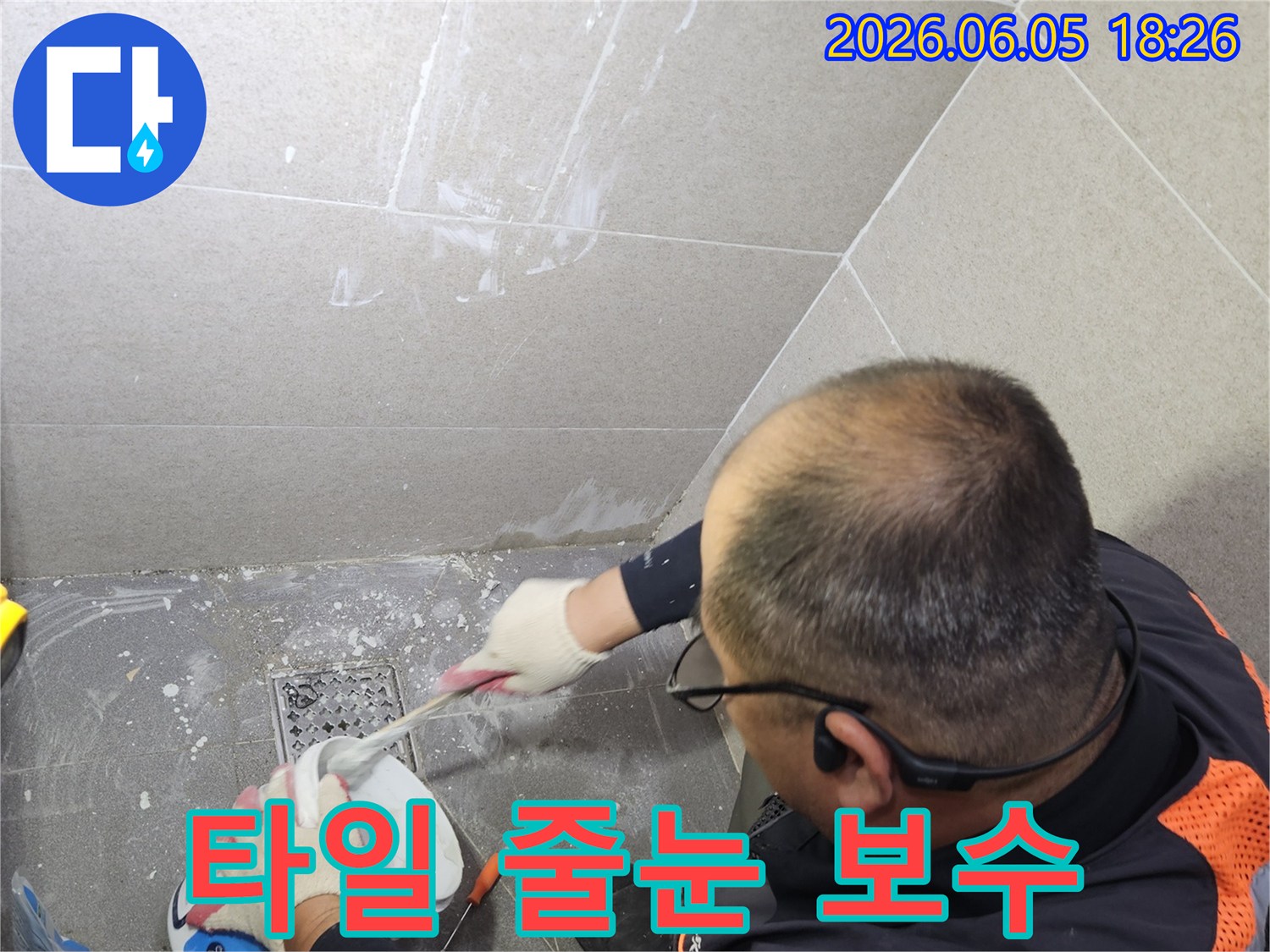 전문 기술자가 욕실 타일 줄눈의 누수 문제를 해결하기 위해-방수 재료를 꼼꼼히 채워 넣어 보수 작업을 진행하고 있습니다