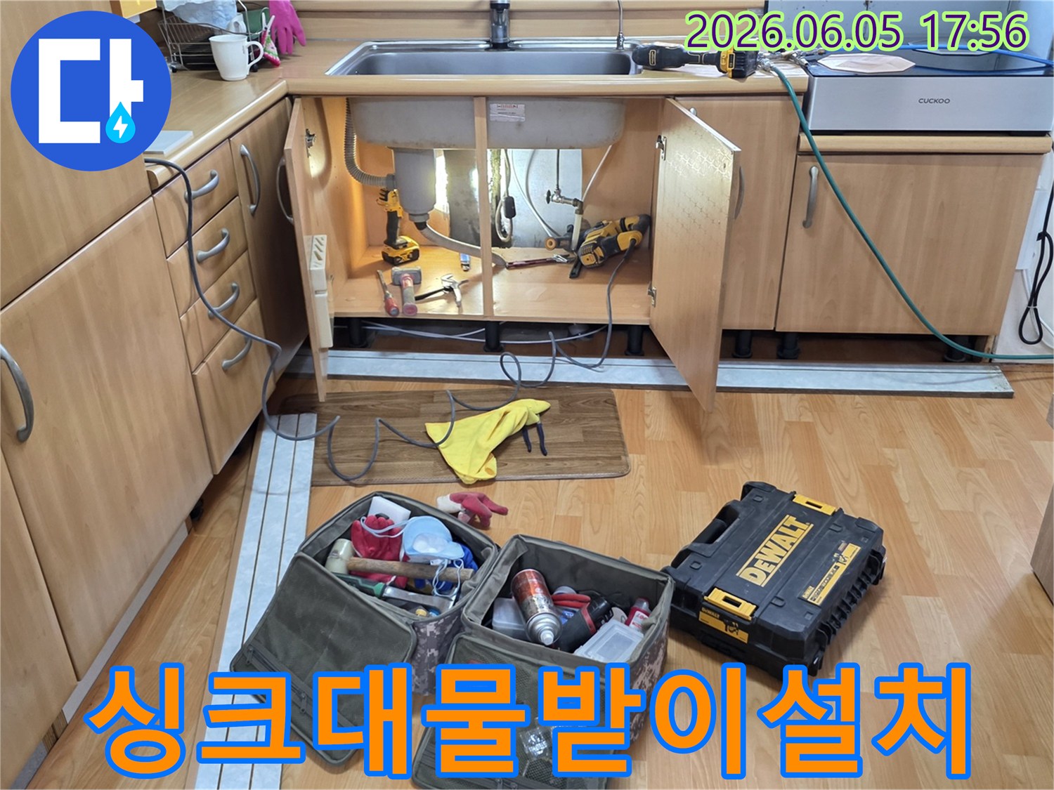 싱크대 하부장에-누수 방지를 위한 물받이 설치를 위해-전문 공구들이-준비된 작업 현장입니다.