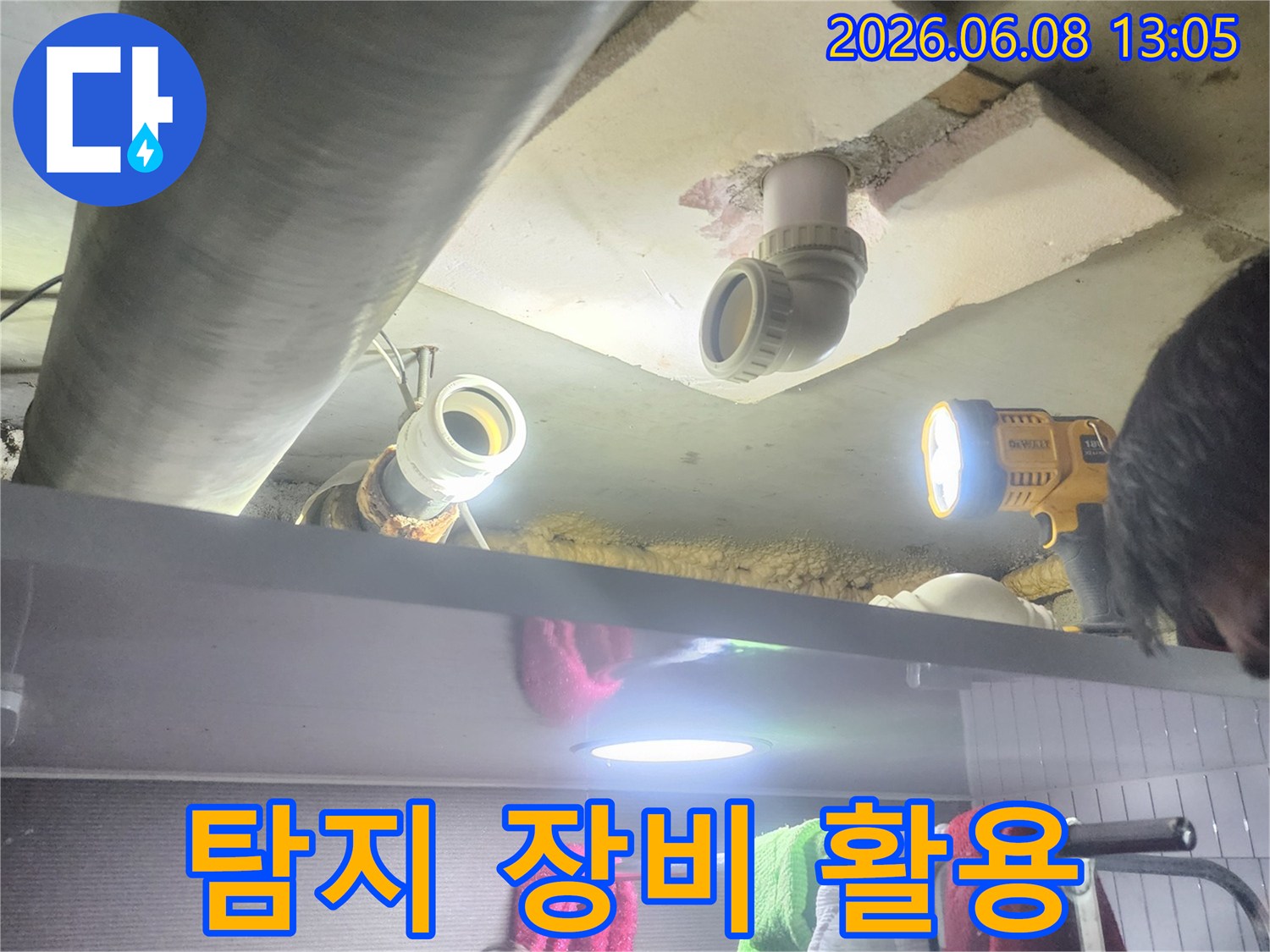 누수 엔지니어가-전문 탐지 장비와-손전등을 사용하여-배관 누수를-찾아내는 모습