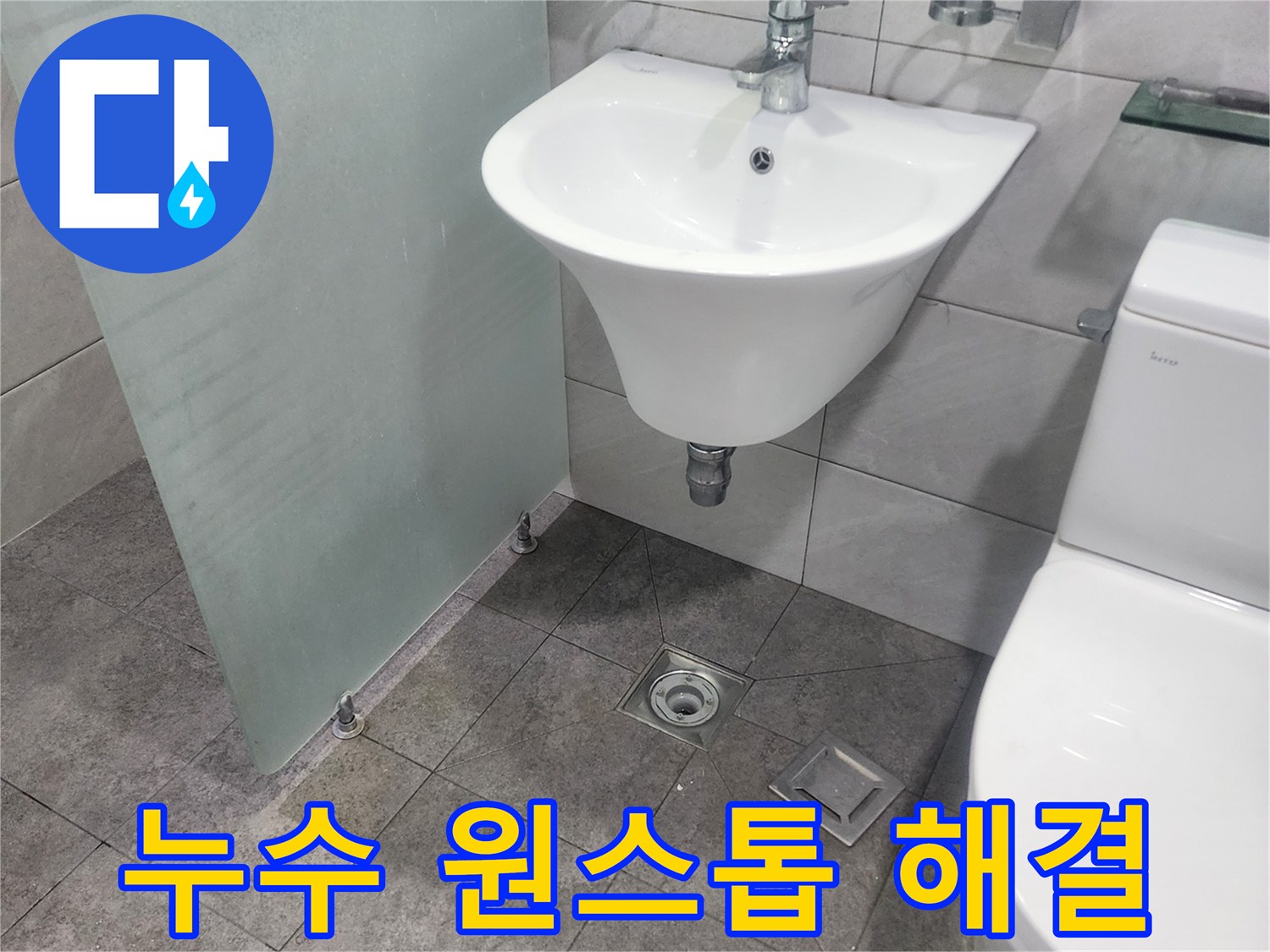 욕실의 세면대-변기-바닥 배수구가-보이는-누수 현장에서-원스톱 해결을 위한-점검이 이루어지고 있습니다