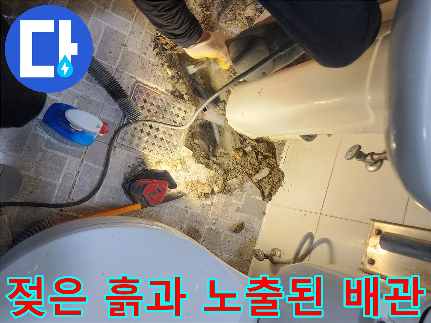 세면대 하부 타일을 제거한 후 드러난 젖은 토사와 누수 배관의 모습