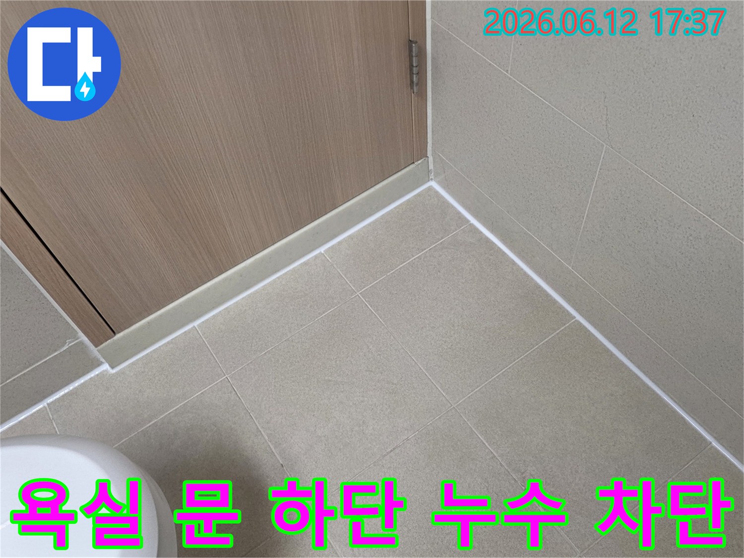 영등포-아크로타워-스퀘어-욕실-문-하단과-바닥-타일-경계에-새로운-방수-실리콘을-시공하여-누수를-완벽하게-차단한-모습입니다