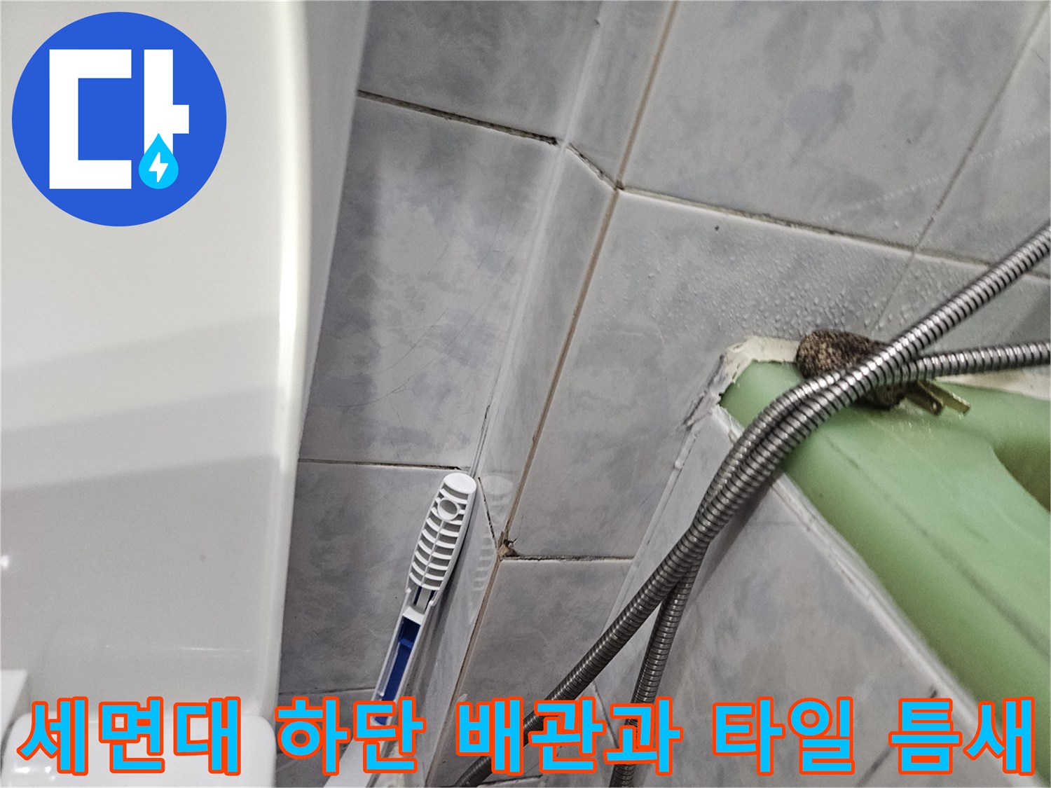 세면대 아래쪽 금속 자재 배관과 물기가 스며든 타일 줄눈 부위입니다.