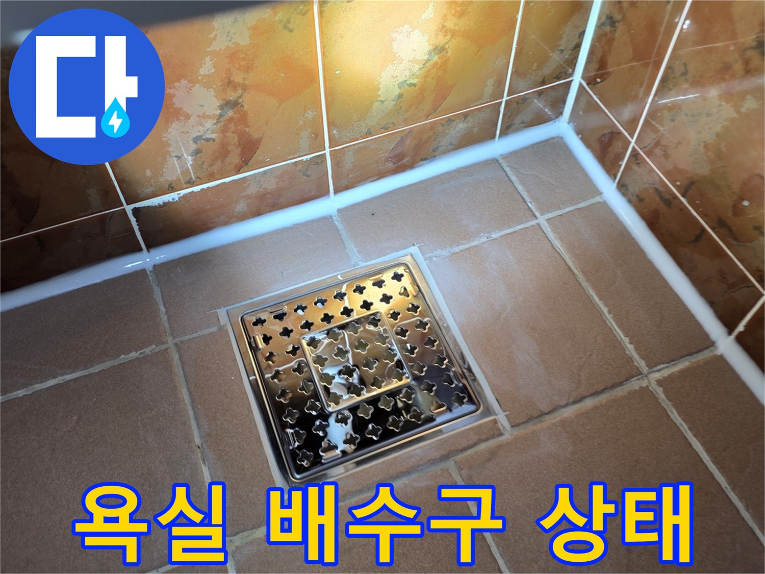 동두​큼 욕실 바닥의 스테인리스 배수구와 타일 마감 상태를 보여주는 사진입니다.