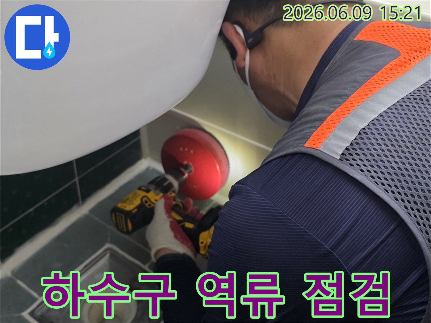 안전-조끼를-입은-전문가가-욕실-배수구-근처에서-누수-원인을-찾기-위해-정밀-장비를-사용하여-작업하는-모습