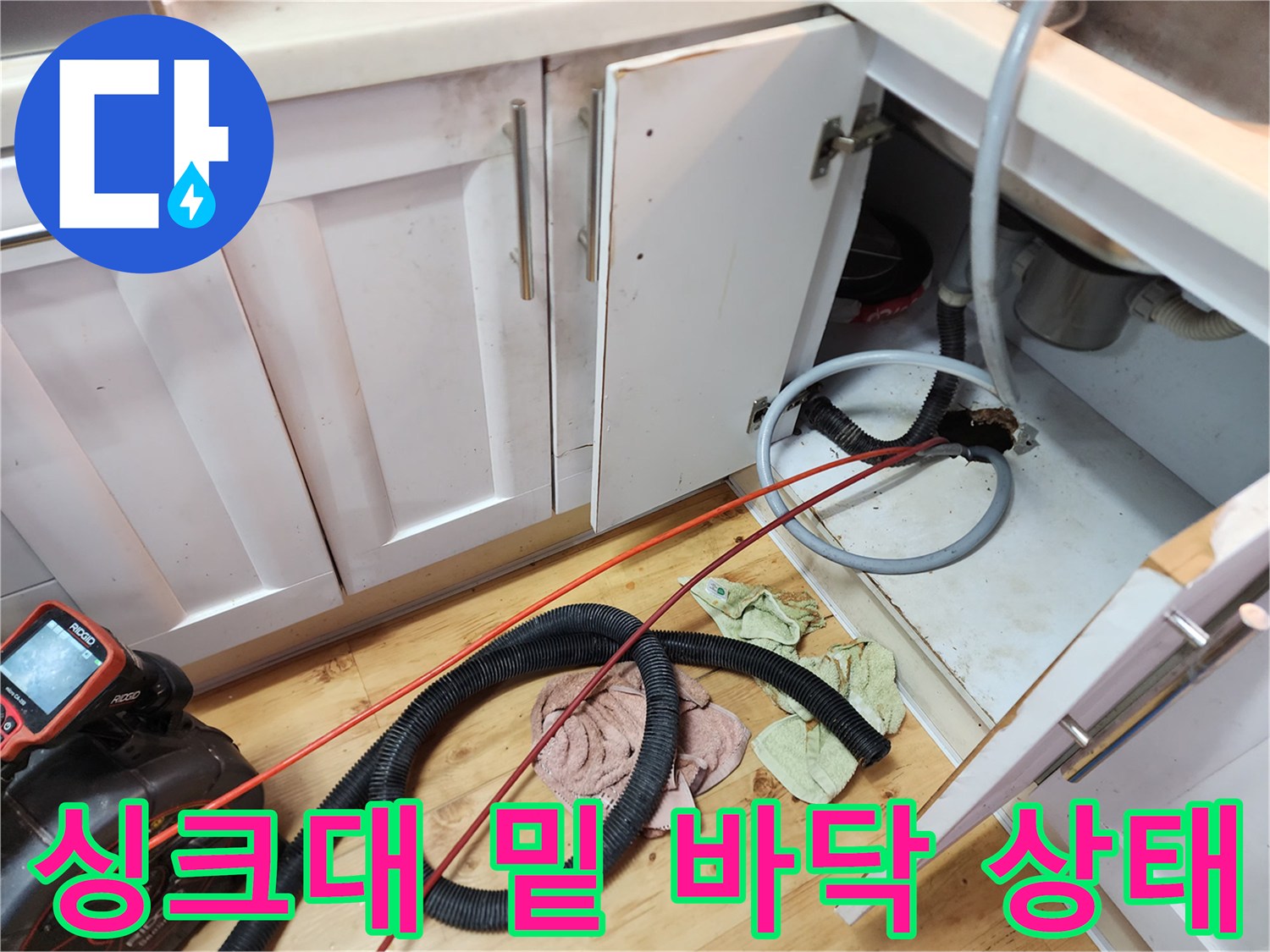 싱크대 아래쪽 배관 주변의 오염된 바닥과 장비들