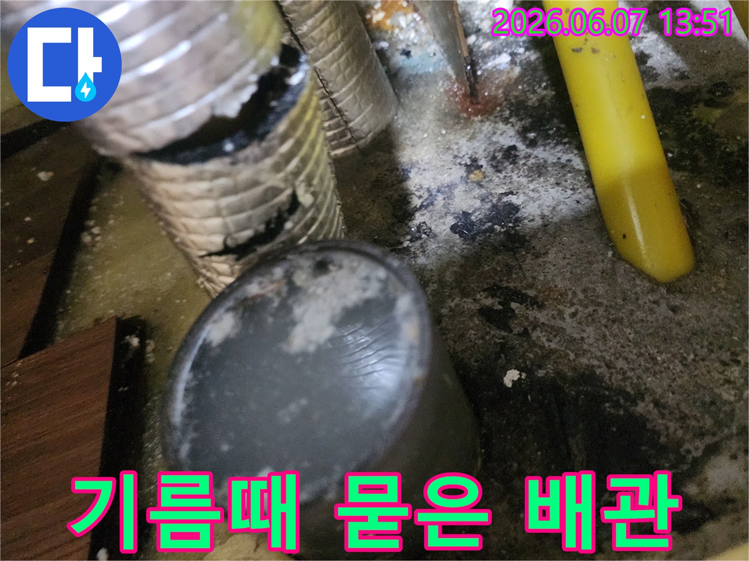 기름 슬러지로 오염된 주름관과 바닥 배수구 주변-역류 흔적을 보여줍니다.
