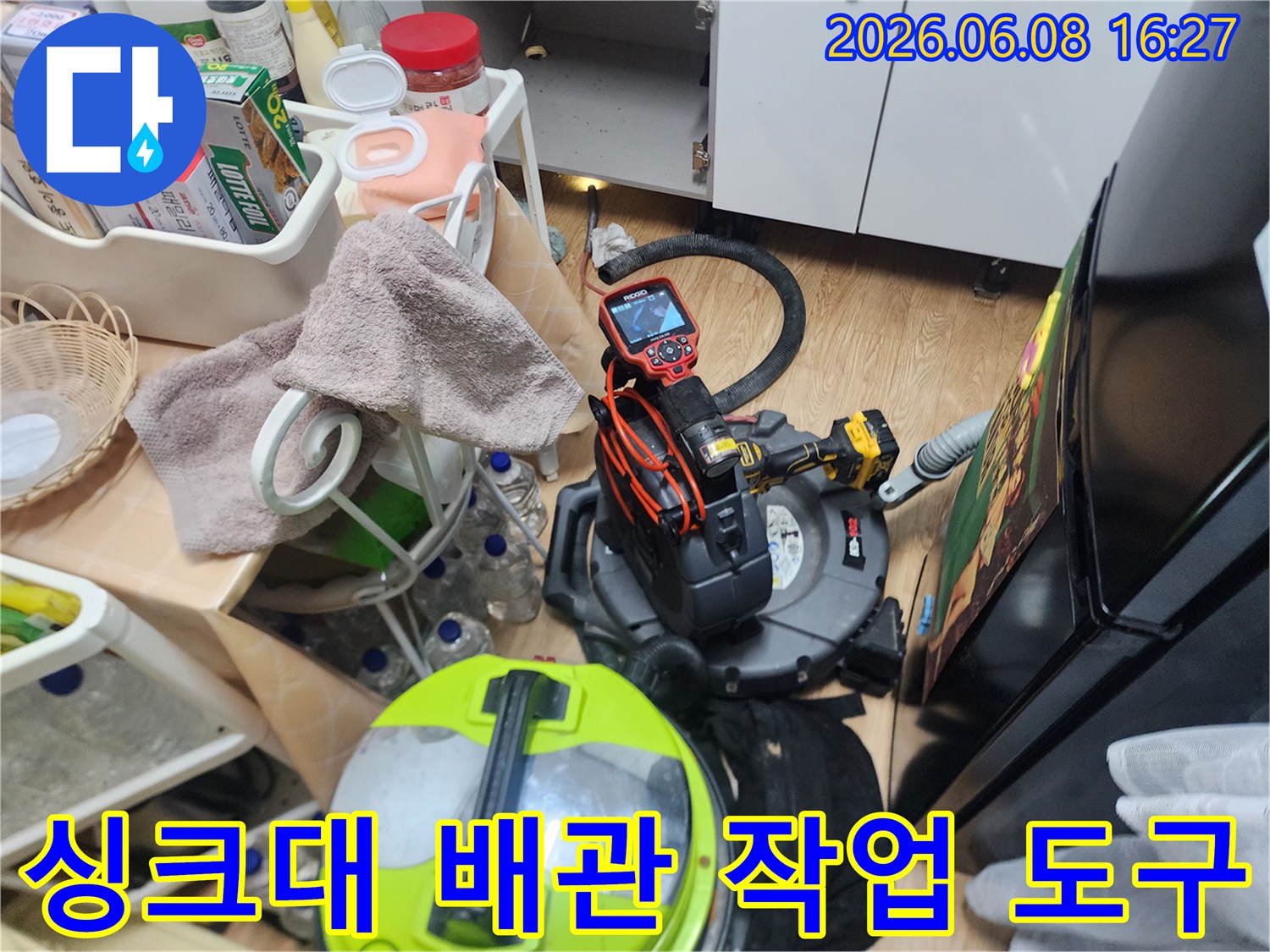 주방 싱크대 하단 배관 작업을 위해 배치된 전문 청소 장비 세트