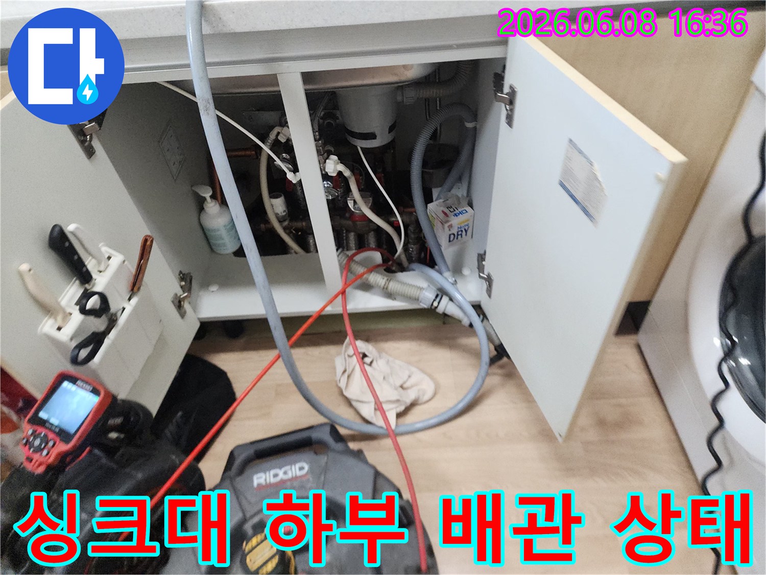 복잡하게 연결된 싱크대 하단 배관과 작업용 리지드 장비