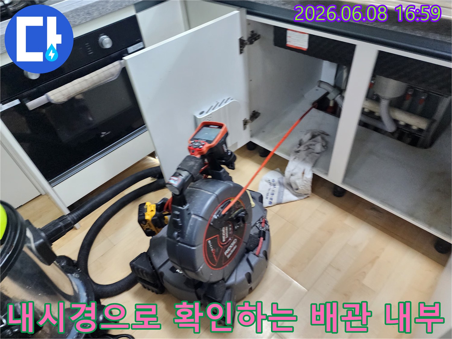 싱크대 하부장 아래에서-배관 내시경 카메라를 투입하여-상태를 점검하고 있습니다