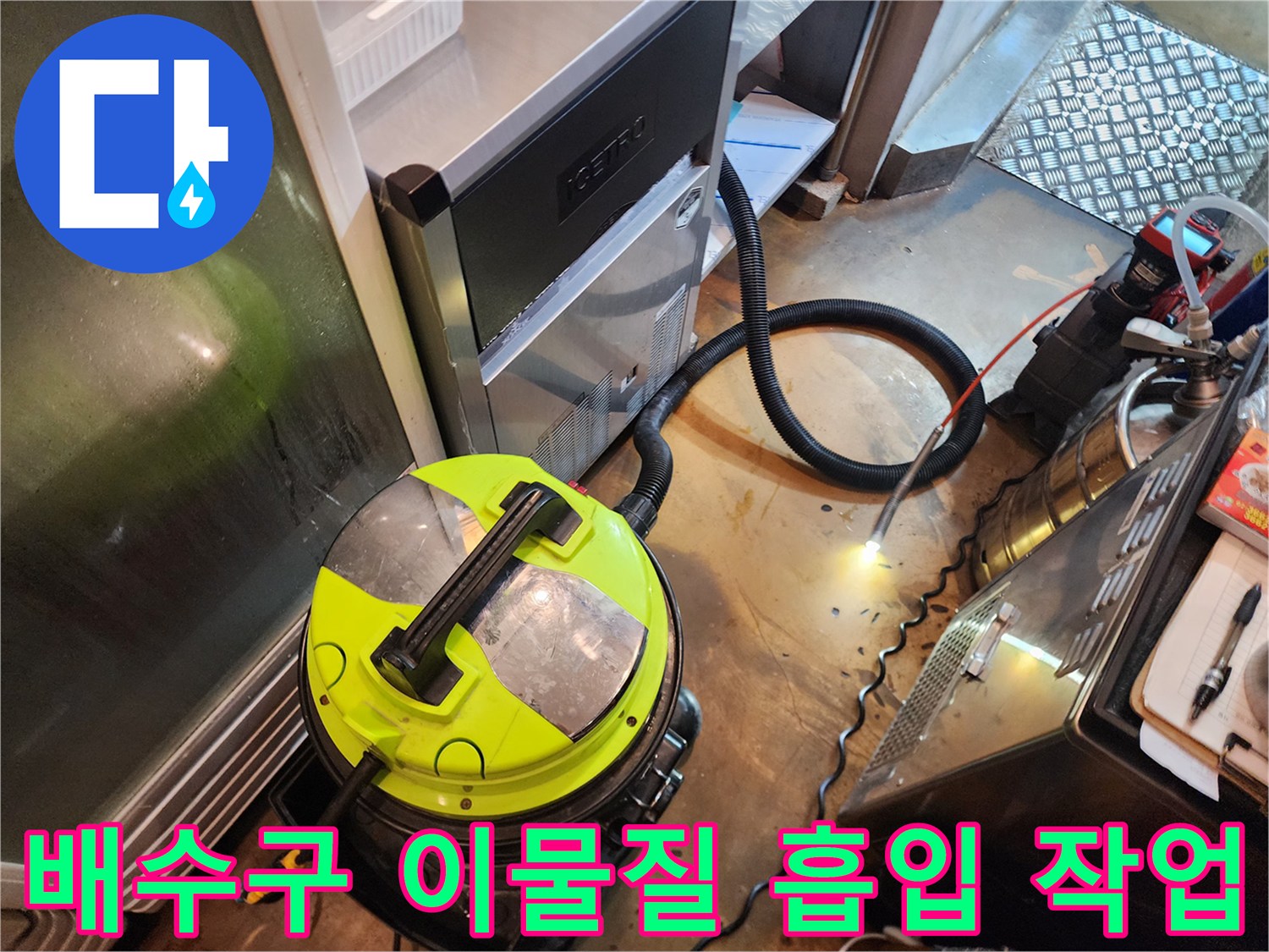 노란색 석션 장비와-검은색 호스를 이용해 배관 속 오물을 제거하는 중입니다.