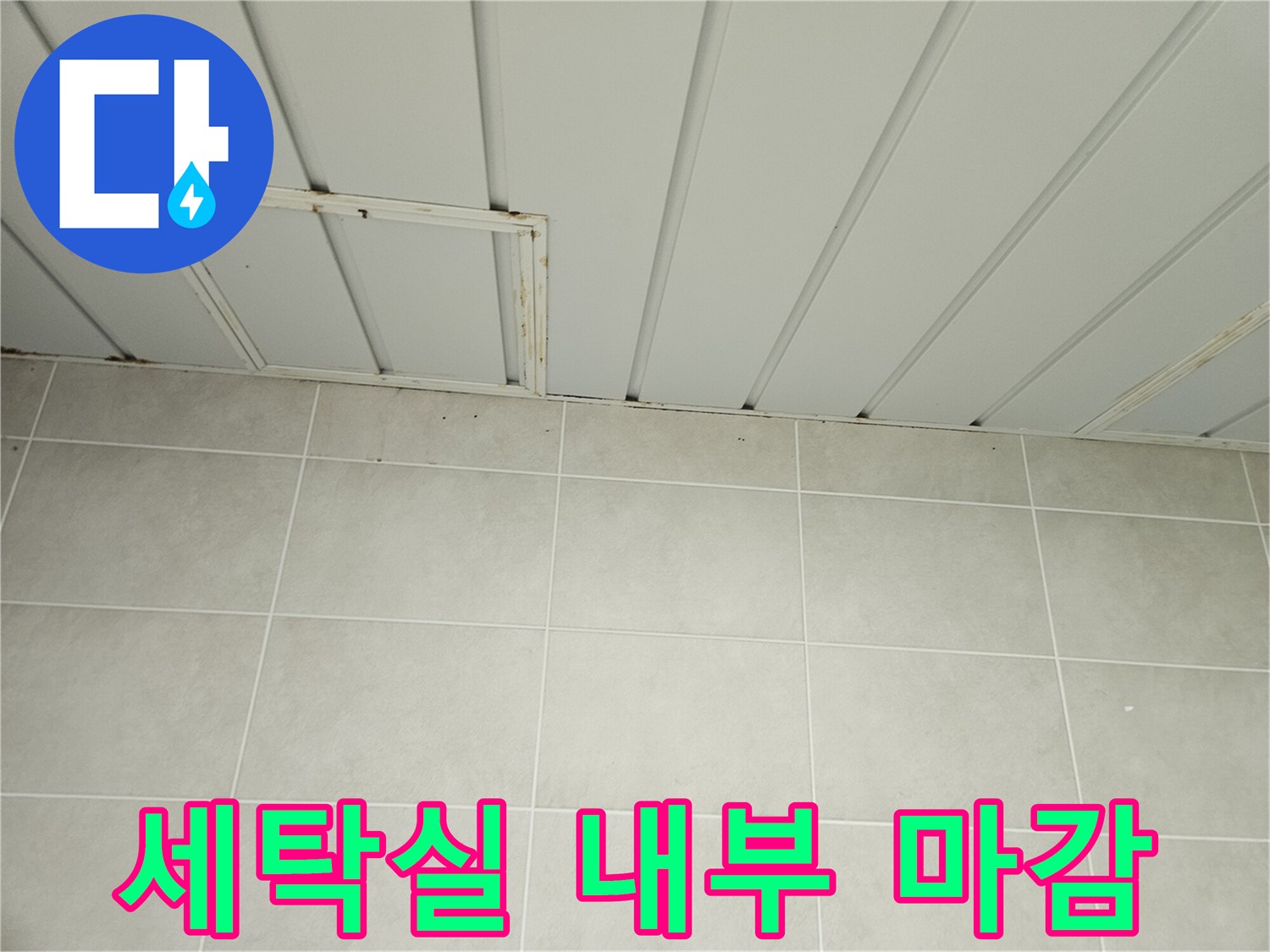 세탁실 천장 판넬과 하단부 베이지색 타일 벽면의 접합부