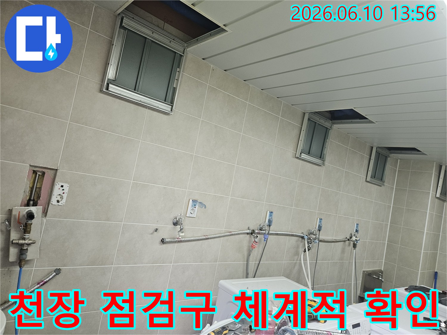 세탁실 천장의 여러 점검구들을 순차적으로 열어-내부 배관과 슬라브 상태를 체계적으로 확인하는-전문가의 작업 모습