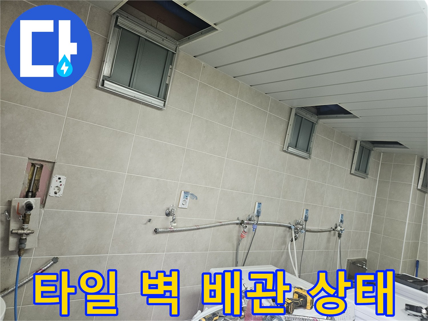 조종면 세탁실 내부-노출된 수도 배관과 타일벽