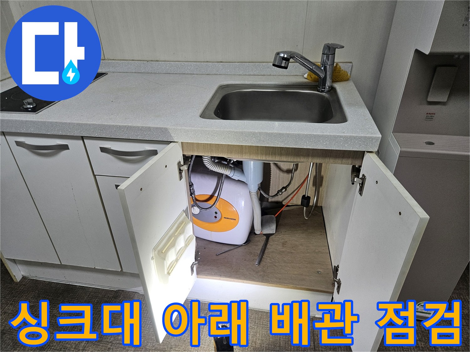 주방 싱크대 하부 수납장 내부에 노출된 배관 시설물