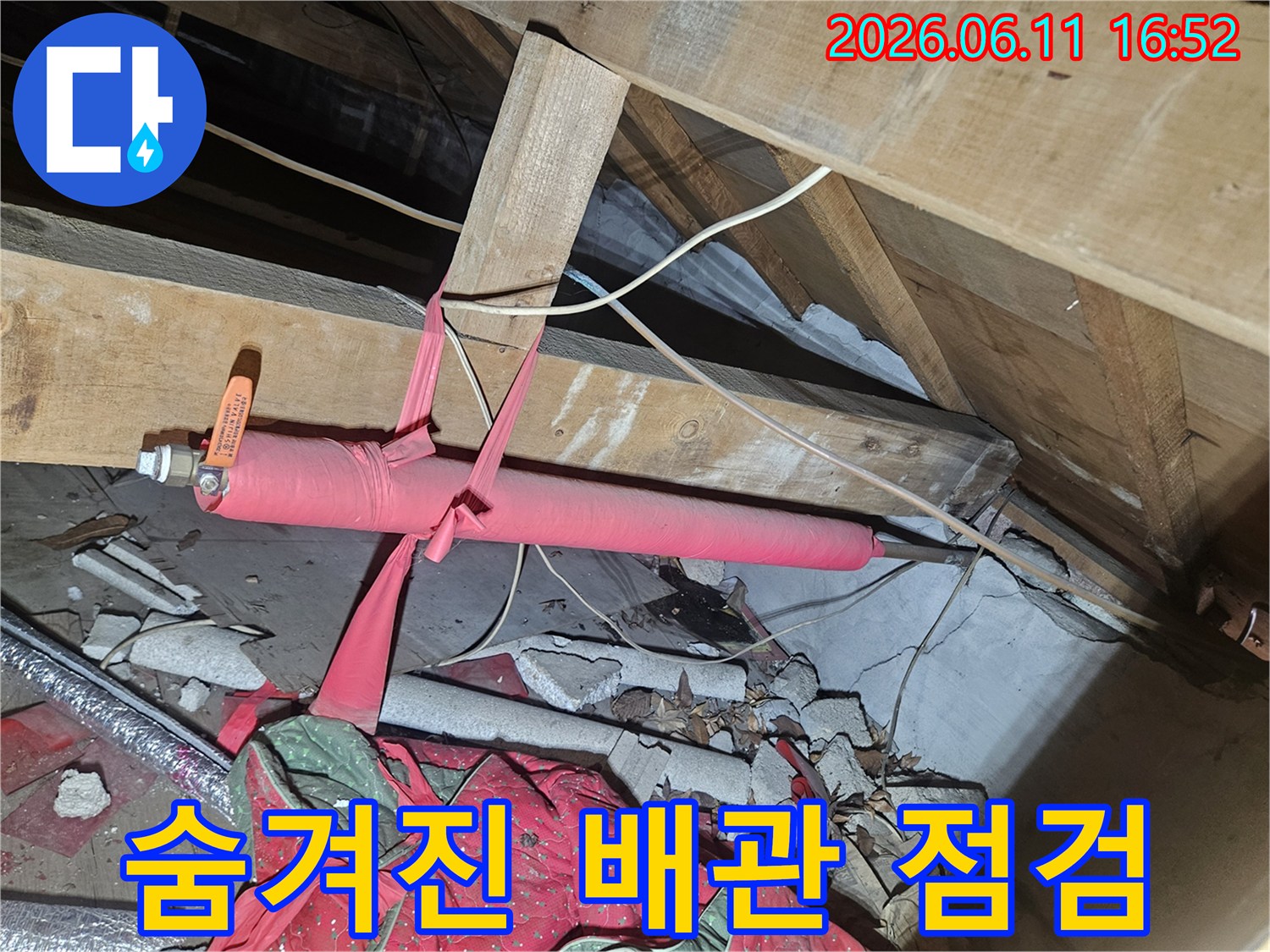 복잡한 천장 구조물 사이로-노출된 수도 배관에-새로운 보온재를 감아-누수 예방을 강화하는 중입니다.