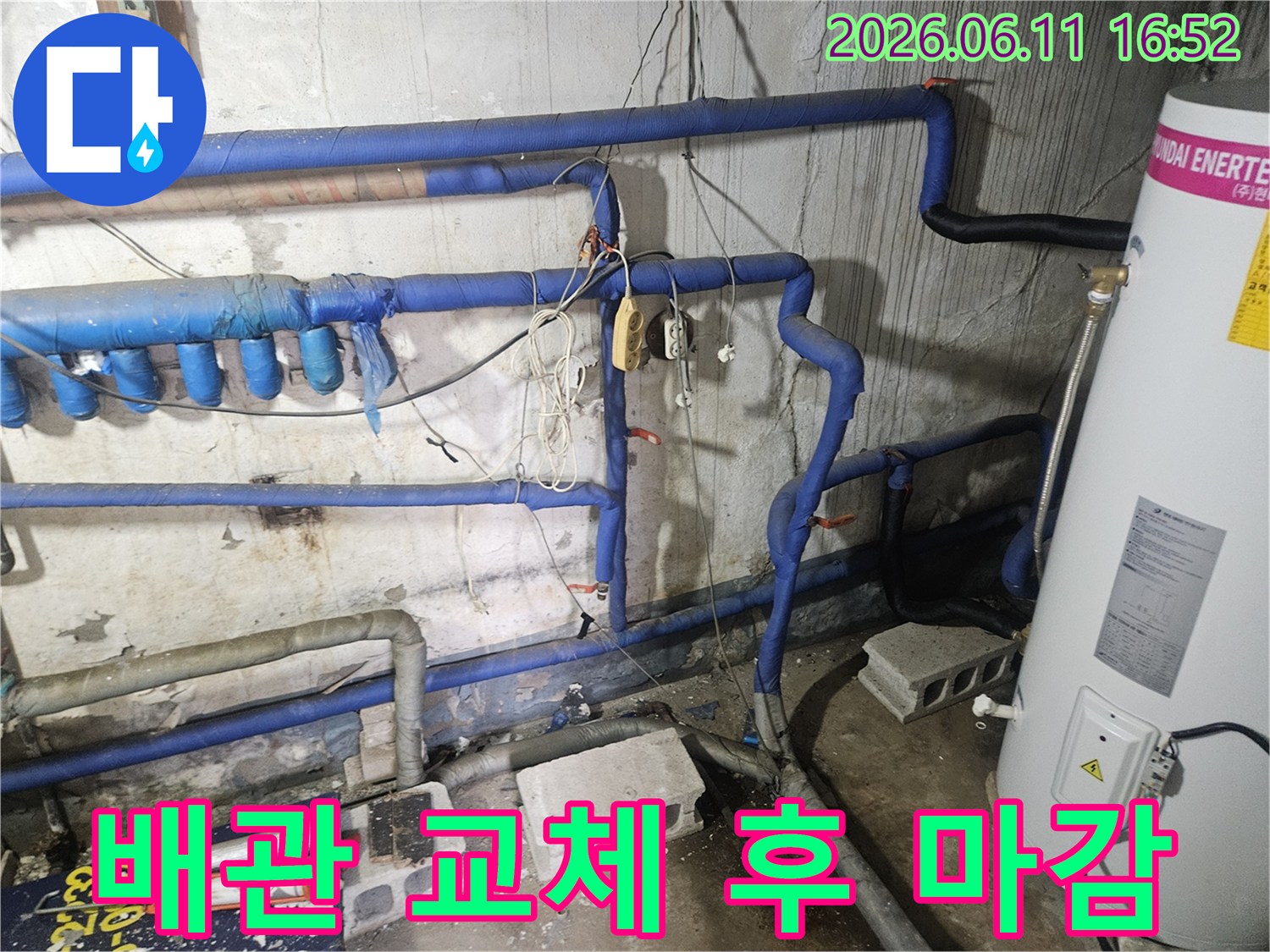 새롭게 교체된 배관과-파란색 보온재가 보이는-주변 마감 처리가 진행 중인-누수 수리 현장입니다