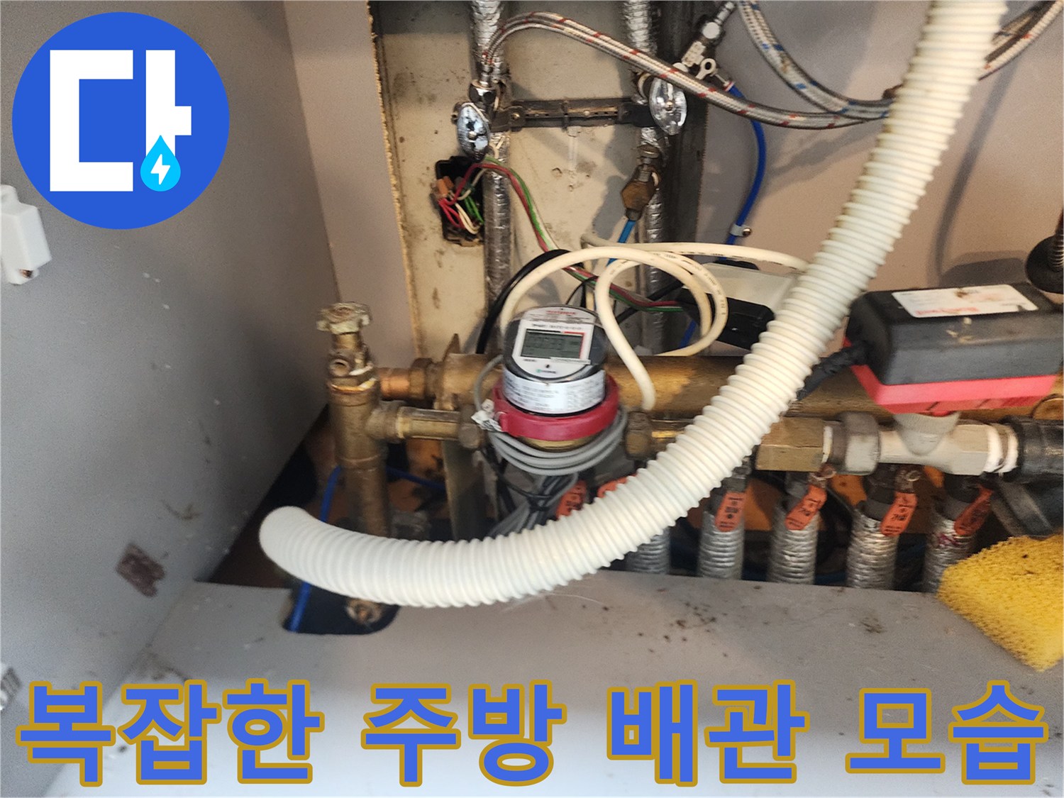 수도 계량기와 연결된 싱크대 하부 금속 배관 상세 사진