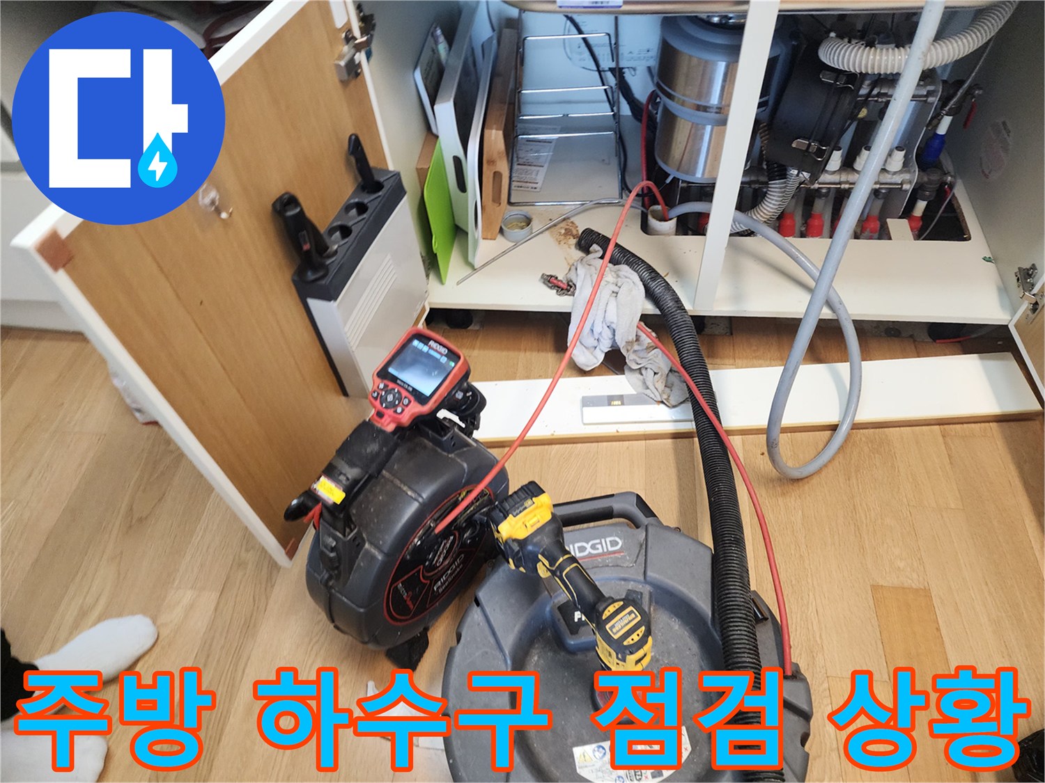 싱크대 아래쪽 작업 공간-내시경 카메라로 배관 내부를 관찰하는 모습