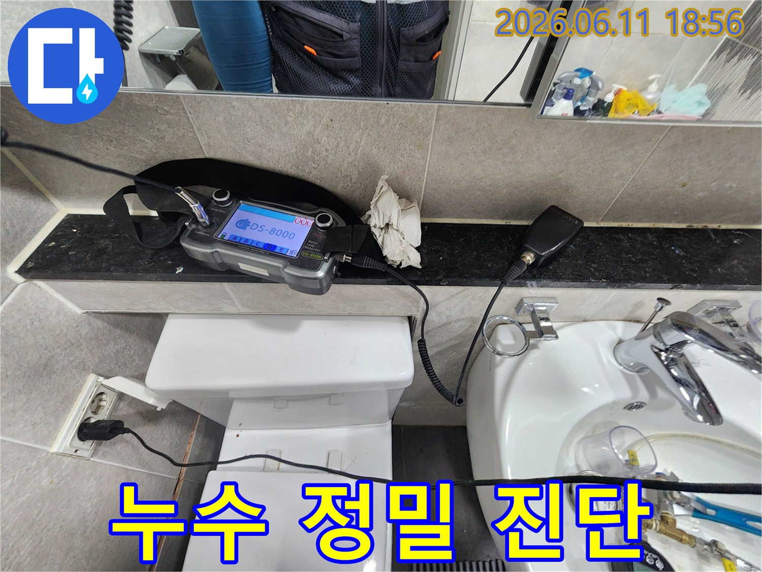 누수-엔지니어가-화장실-배관의-누수-지점을-정밀하게-진단하기-위해-청음-장비를-사용하여-탐지하는-모습
