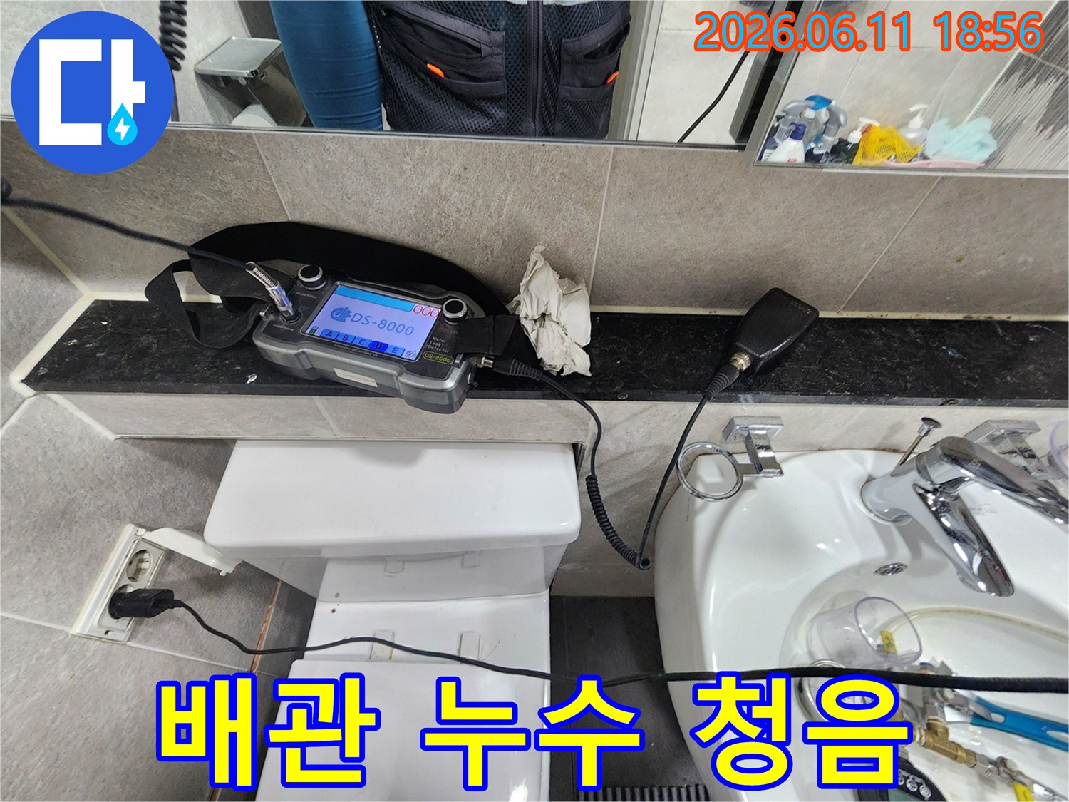 누수-전문가가-화장실-배관의-숨겨진-누수-지점을-찾기-위해-청음-장비를-사용하여-정밀하게-탐지하는-모습
