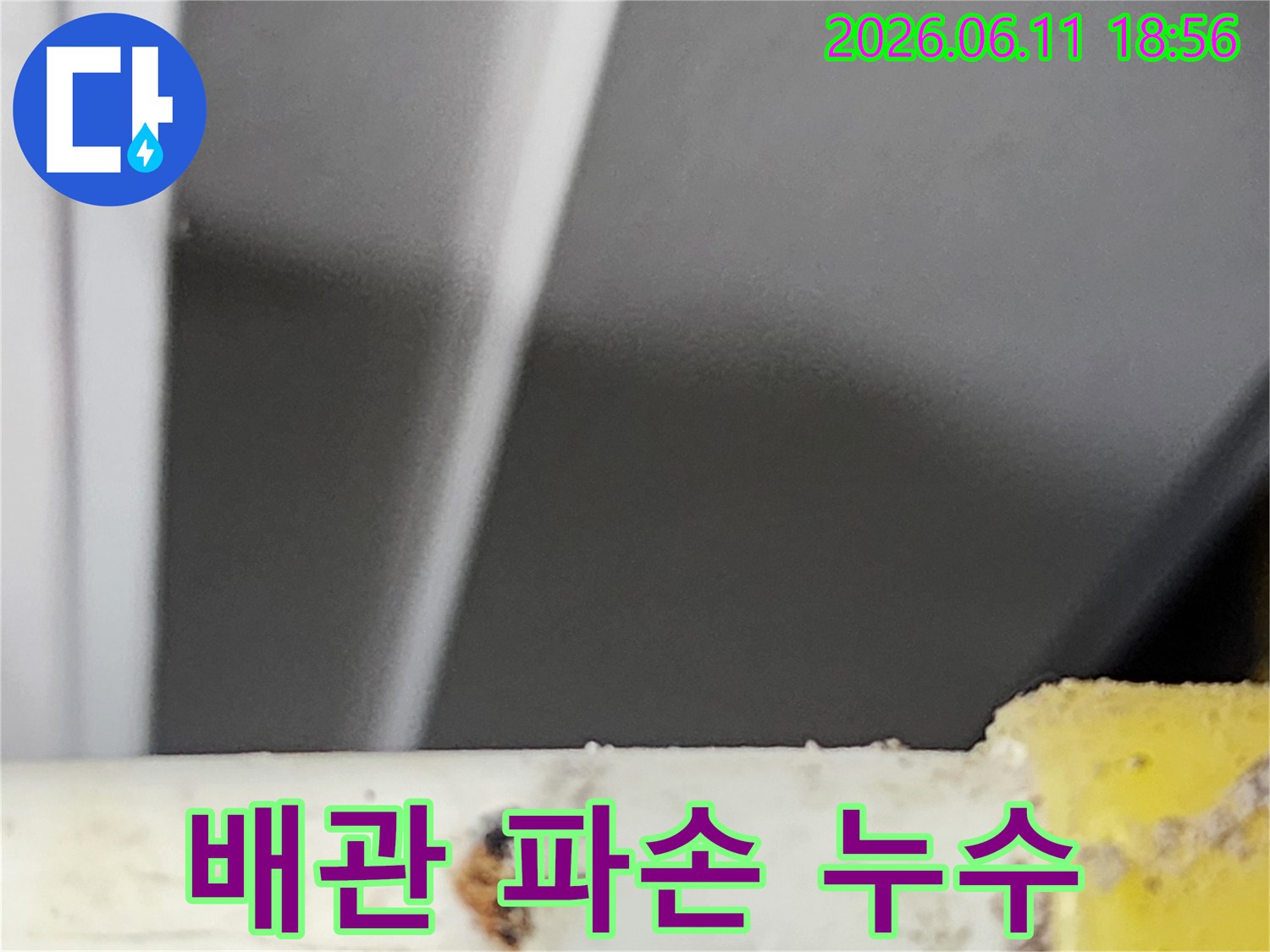 아파트 배관에서 발생한-파손으로 인한 누수 지점을-전문가가 긴급하게 확인하는 현장 사진입니다.