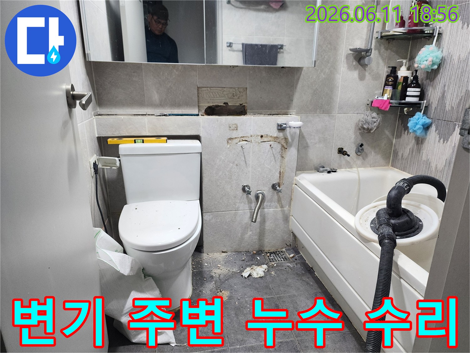 이 이미지는-동대문구 화장실에서-변기 주변에서 발생한 누수를 해결하기 위해-타일을 제거하고-배관 연결 부위를 점검하는-수리 현장을 보여줍니다