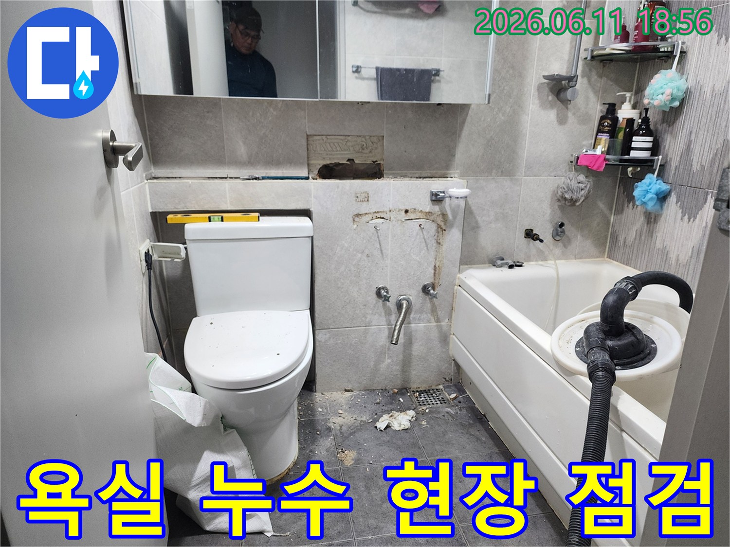 이 이미지는-서울 동대문구 아파트 욕실에서-누수 원인을 찾기 위해-타일을 제거하고-배관 상태를 점검하는-누수 탐지 및 수리 과정을 보여줍니다