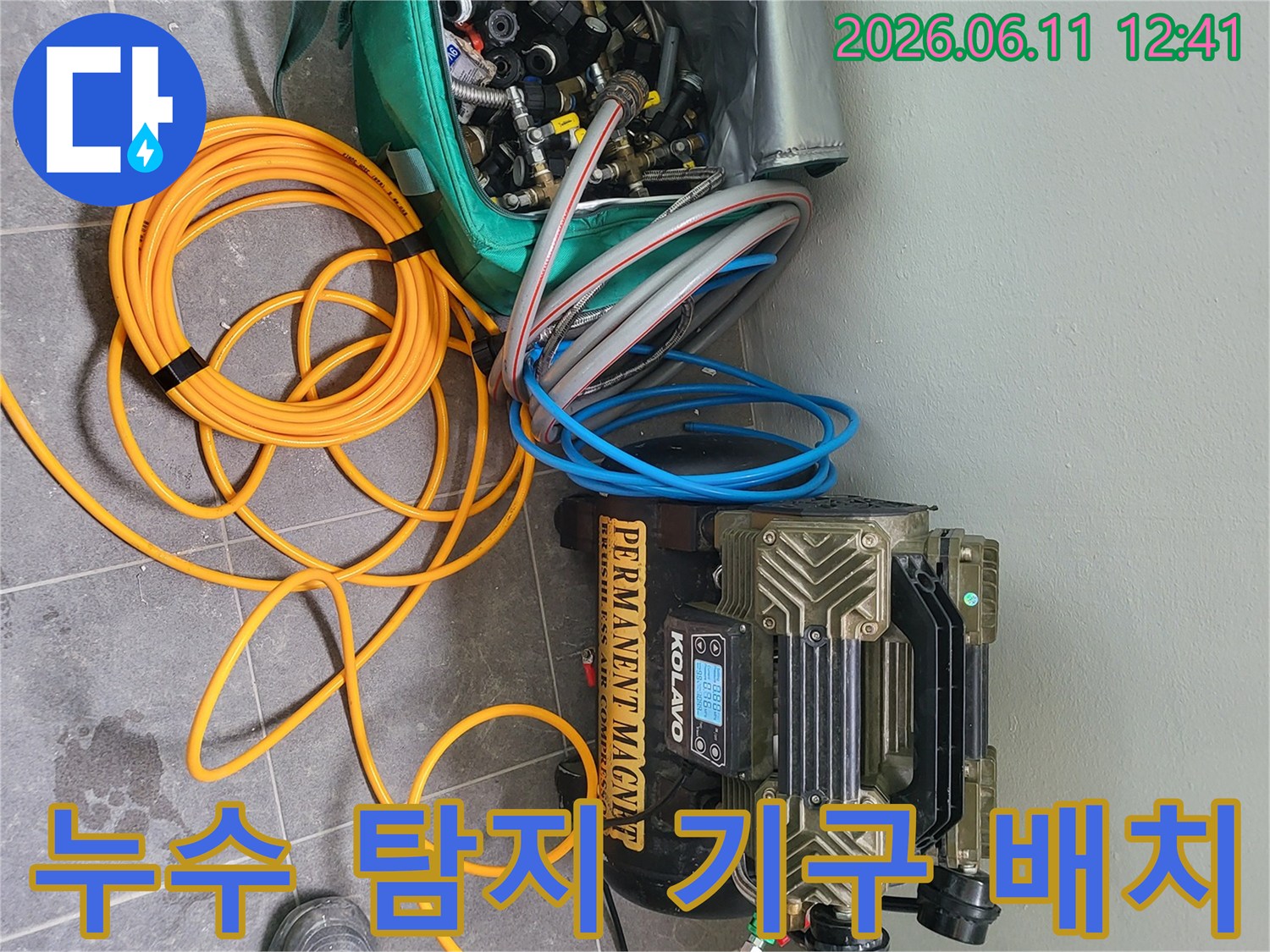 누수 진단을 위해 필요한 압축 장치와 각종 배관 연결 부품들이 현장에 준비된 모습