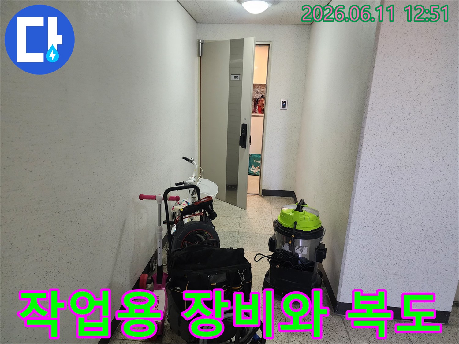 복도에 놓인 배관 작업용 진공 흡입기와 전문 장비 세트