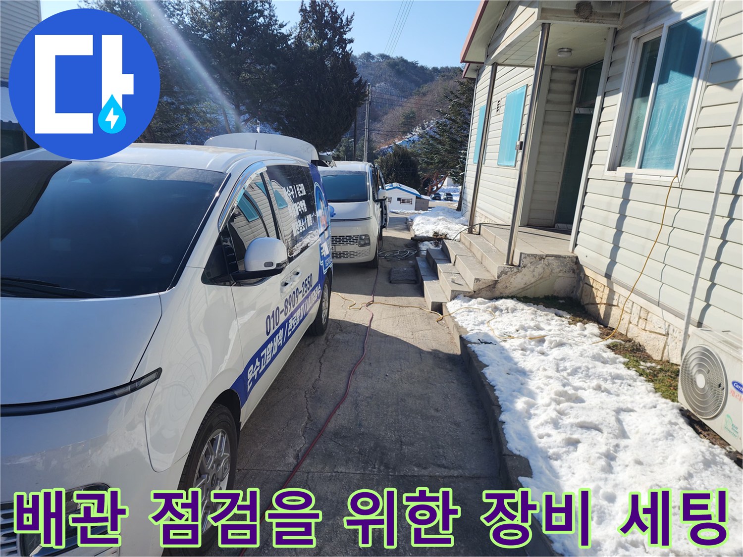 작업 차량에서 나온 호스가 바닥을 가로질러 배관 지점으로 연결된 모습