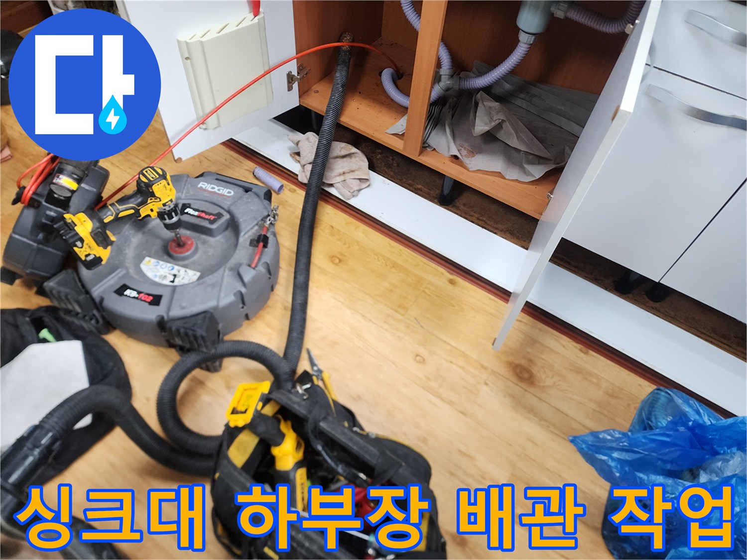 광진구 중곡동 싱크대 하부장 내부에 배치된 리지드 전동 스프링 장비와 배관 점검 모습